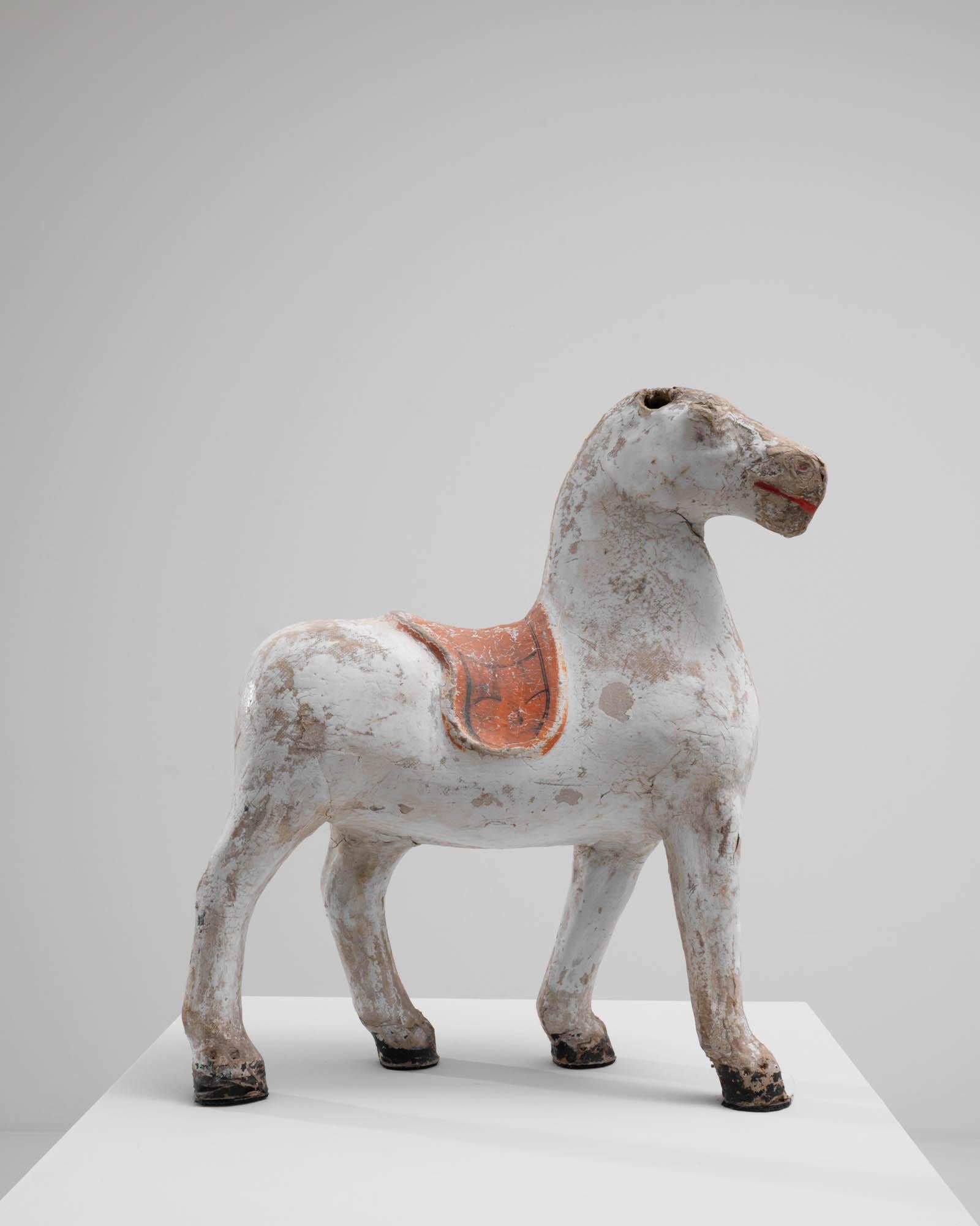 Dekorative Skulptur eines Pferdes, hergestellt in Frankreich um 1900. Auf diesem schönen, patinierten Pferd ruht ein einfacher, gekrönter Sattel. Die leuchtend scharlachrote Farbe im lächelnden Maul dieses königlichen Pferdes verleiht ihm einen
