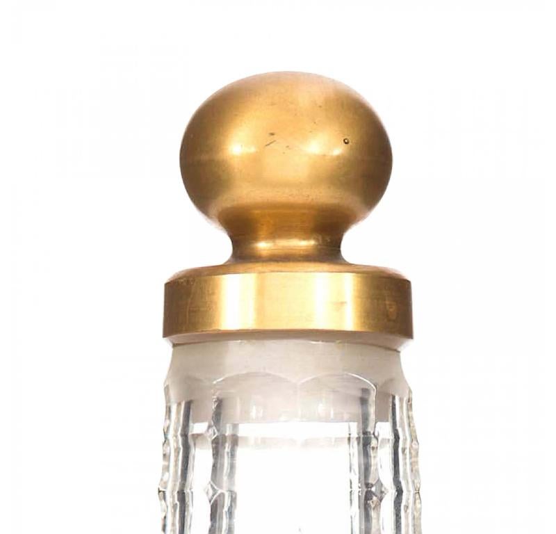 Bottiglia di profumo francese d'epoca in vetro trasparente sfaccettato (LE PARFUM IDEAL by HOUBIGANT) con un lungo collo cilindrico, dettagli dorati e una scena del XVII secolo di un uomo e una donna in un cortile, sotto un tappo dorato a forma di