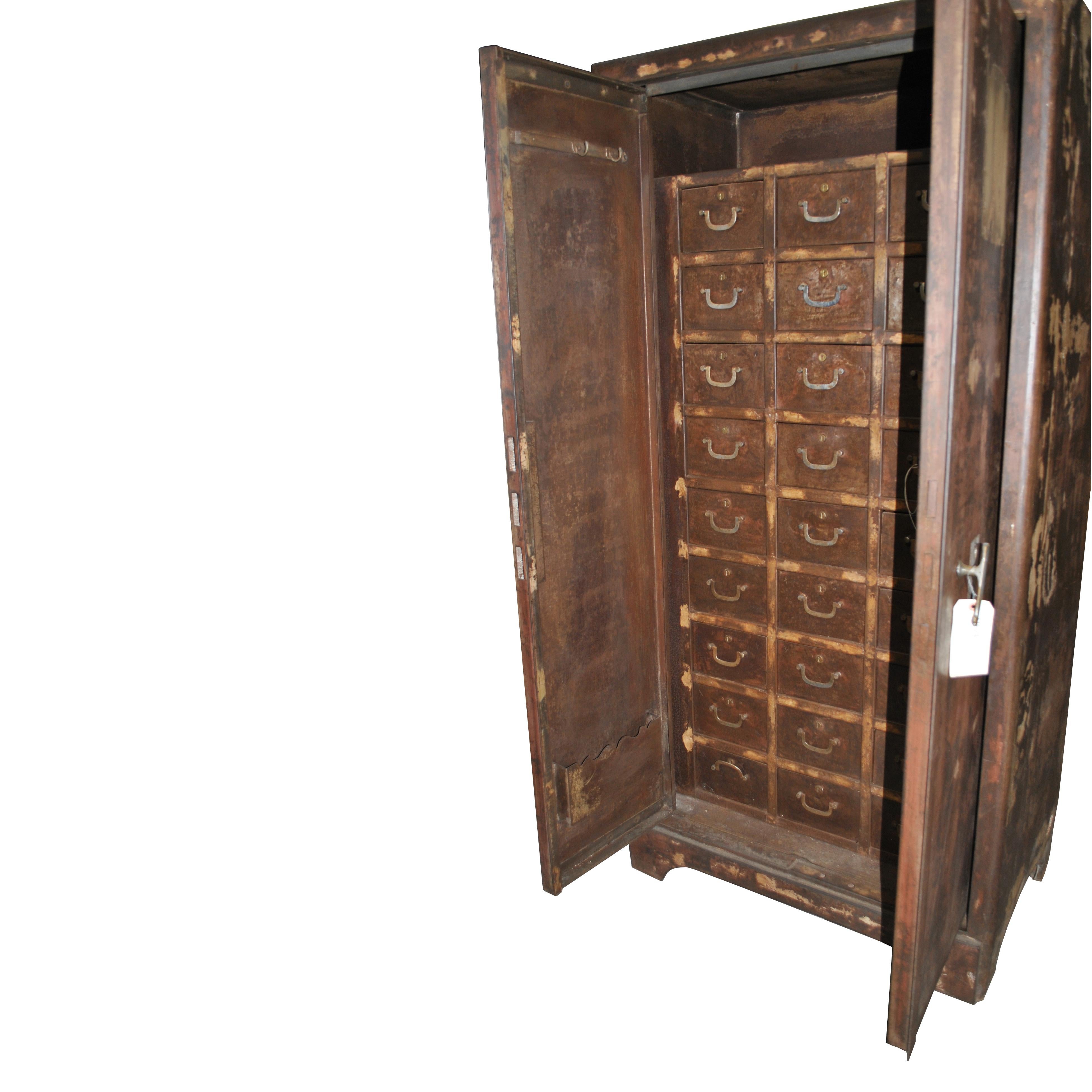 A French storage cabinet possibly from a bank from the earlier part of the 20th century made of steel with a rich patination.  This Industrial Era piece has double doors concealing an interior with twenty-one lockable drawers and additional storage