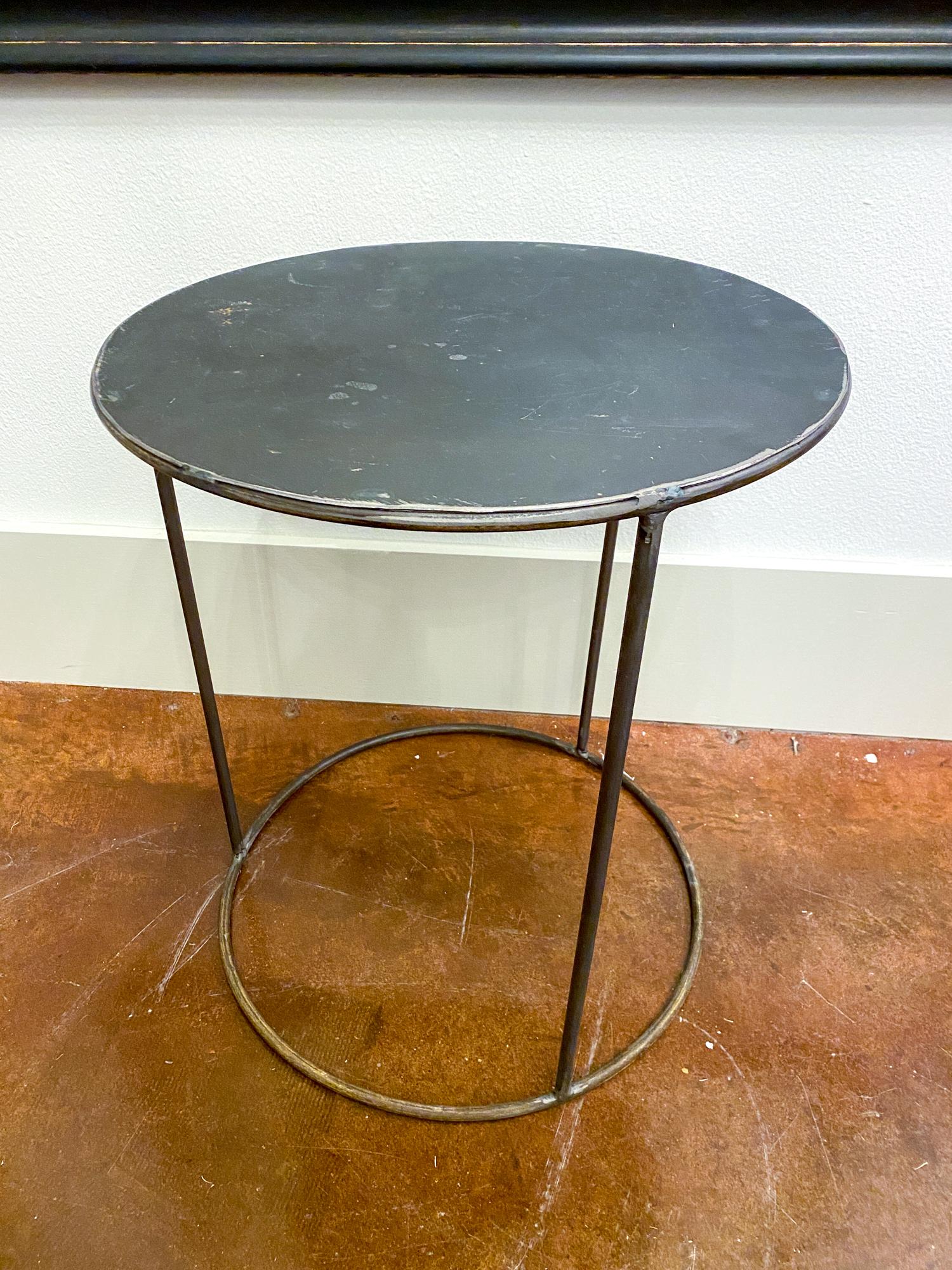 This is a funky and simple vintage French metal side table with an airy, open cylinder-shaped base and a solid top. The piece is lightweight, but sturdy and has patination throughout. It's perfectly sized to place next to a cozy armchair or it could