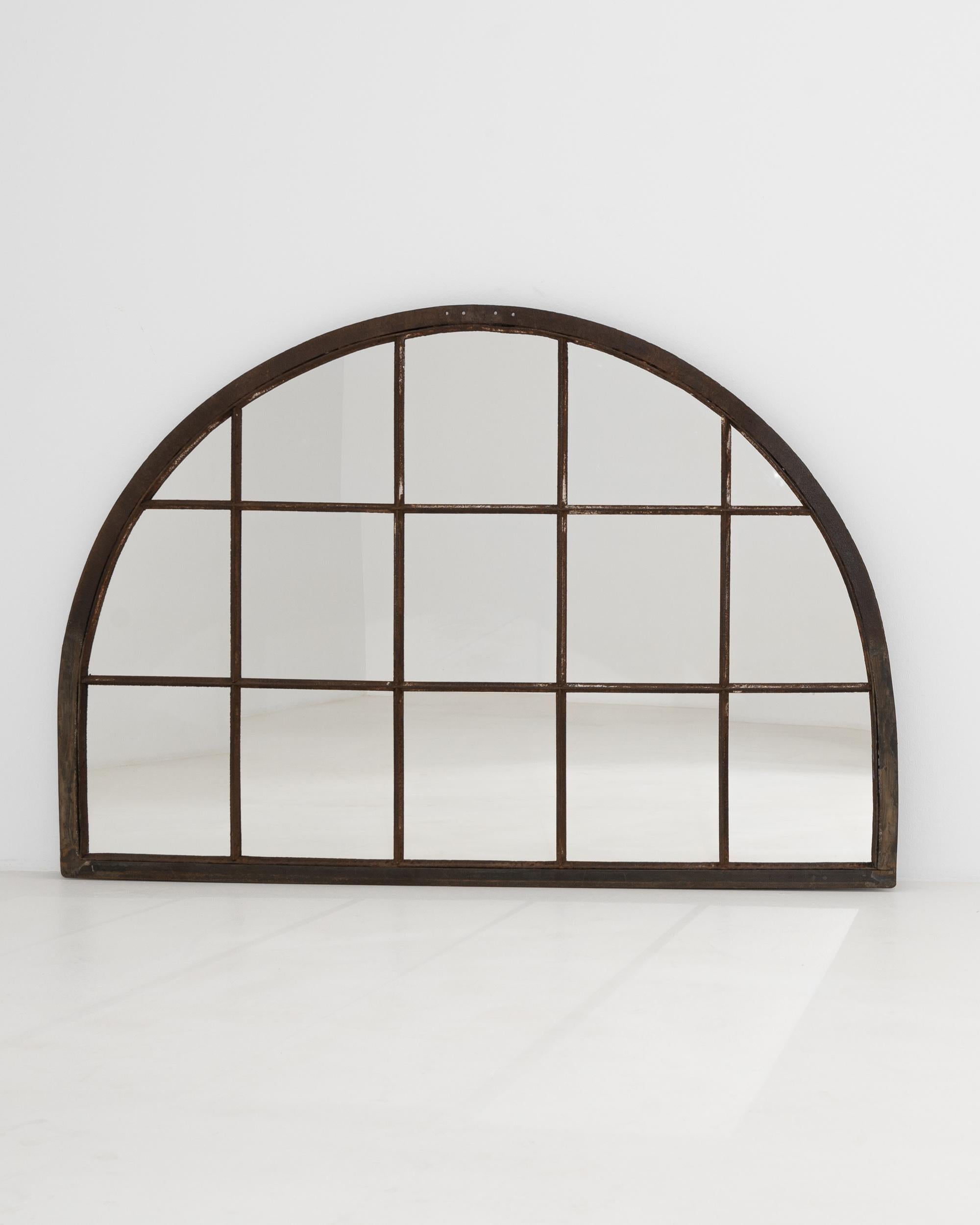 Originally used in a factory, the generous size and stripped back simplicity of this vintage mirror make for a unique Industrial accent. Made in 20th century France, the semicircular form mimics a mullioned window, amplifying natural light within an