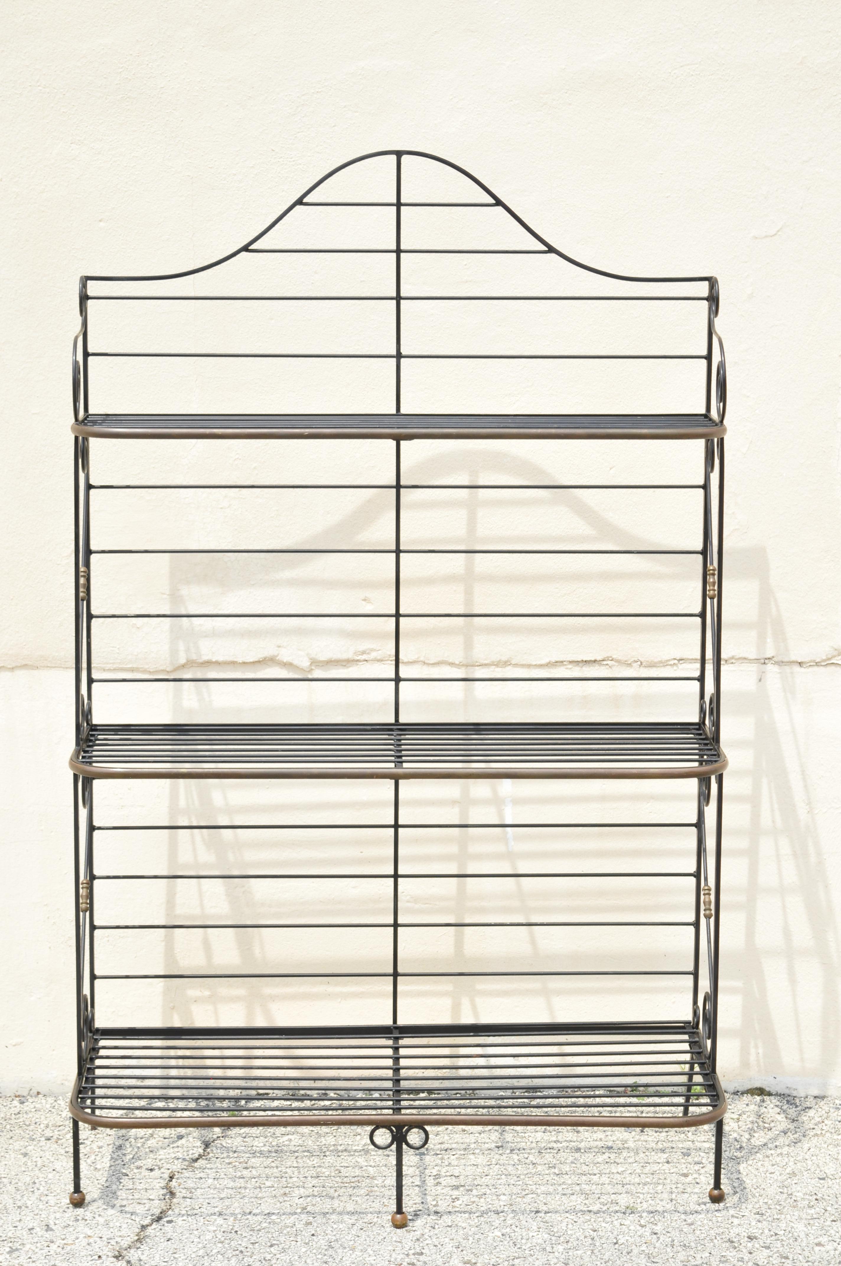 Vintage French iron brass country Provincial 3 tier bakers rack Stand. Item features heavy wrought iron construction, brass trim, iron scrollwork frame, 3 graduating tiers, brass ball form feet. Circa mid to late 20th century. Measurements: 77