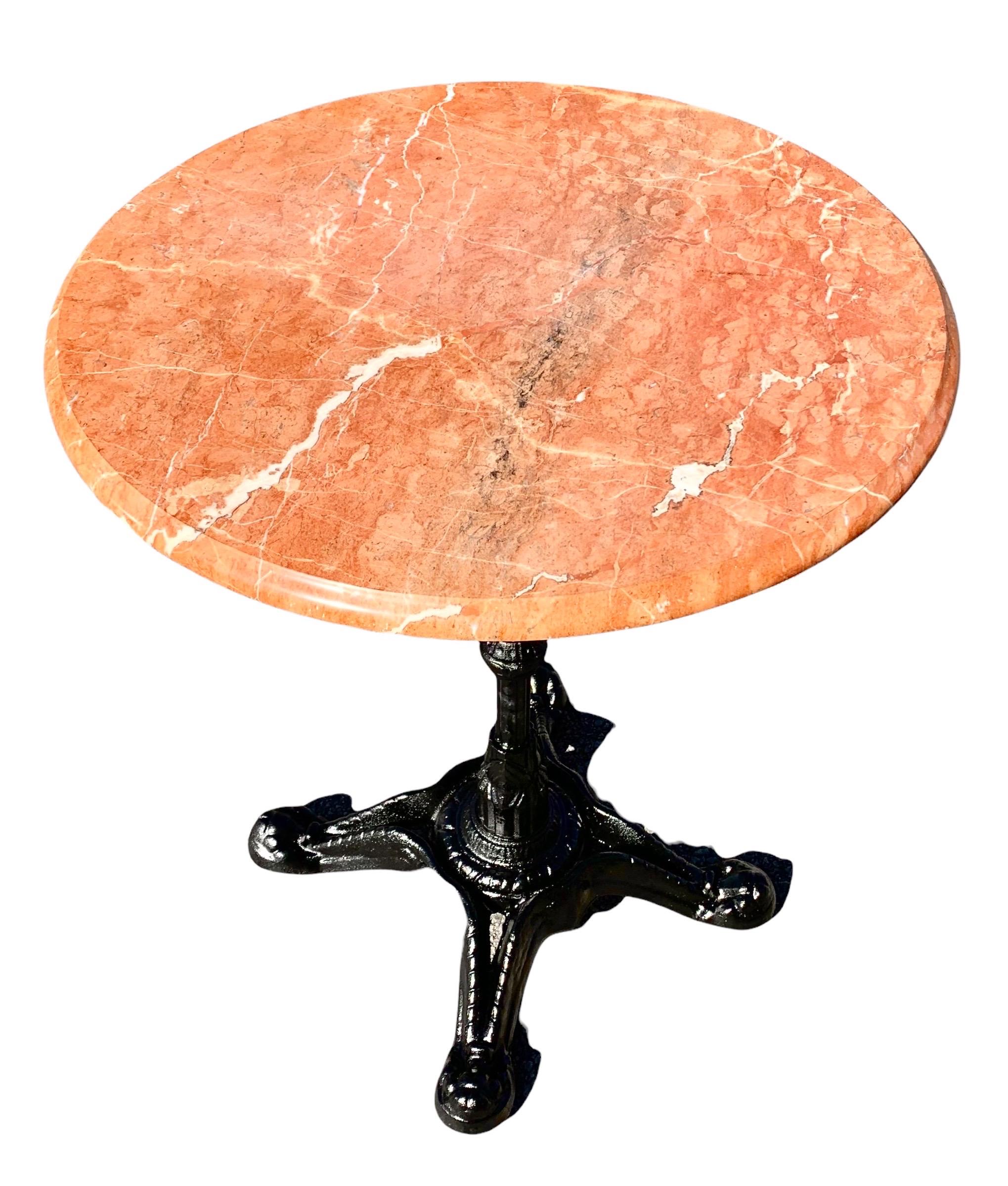 A charming French iron and marble bistro table with sienna color ogee edge marble and black enamel painted iron base. As seen in the coffee shops and bistro's of Paris, this table exudes charm and style and can also be used outside under a covered