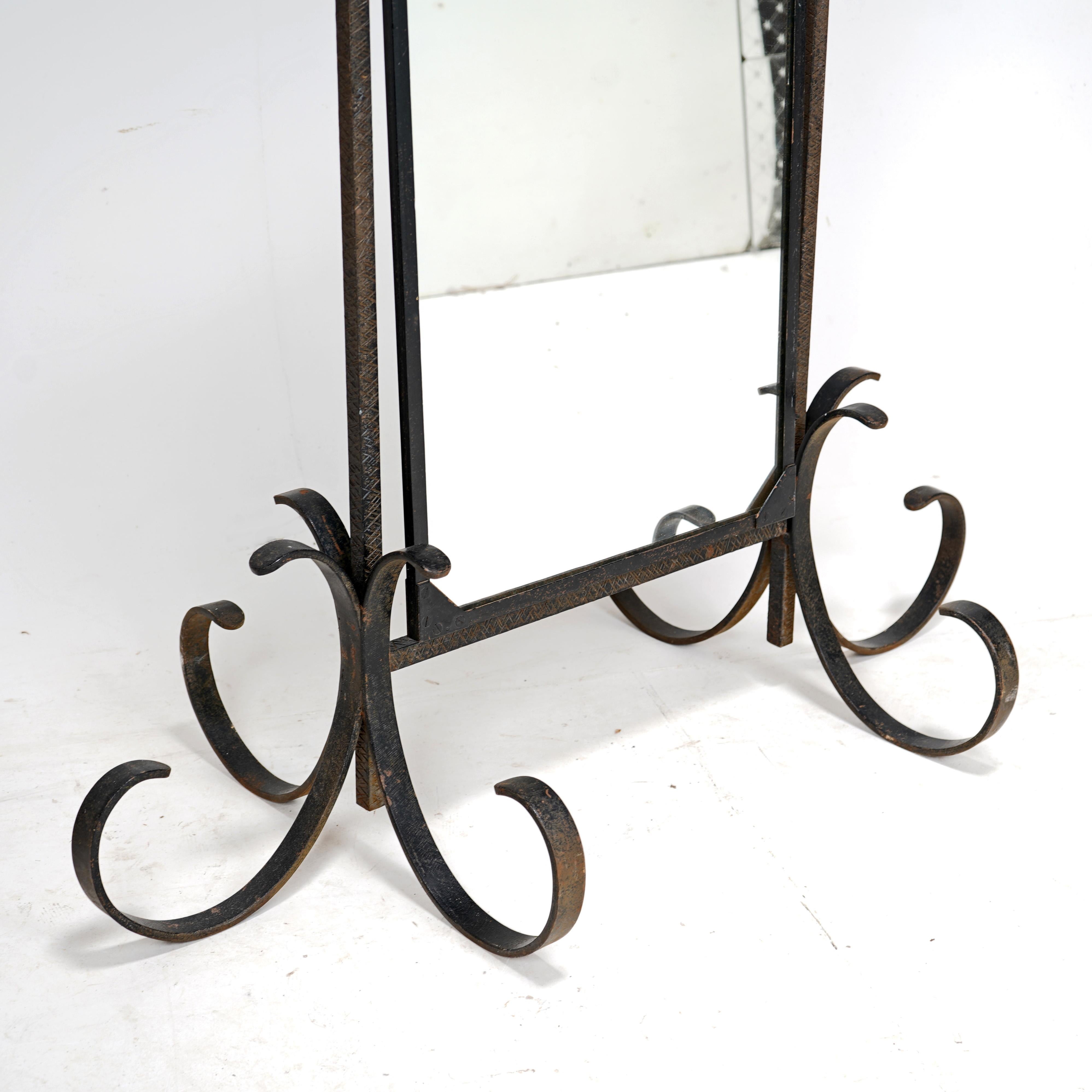  A very striking iron cheval mirror, French circa 1950s.
A well made piece with scored wrought iron bars on spiralling steel feet. The brass knobs on the side twist and tighten, holding the mirror firm in the desired position.
A unique piece that