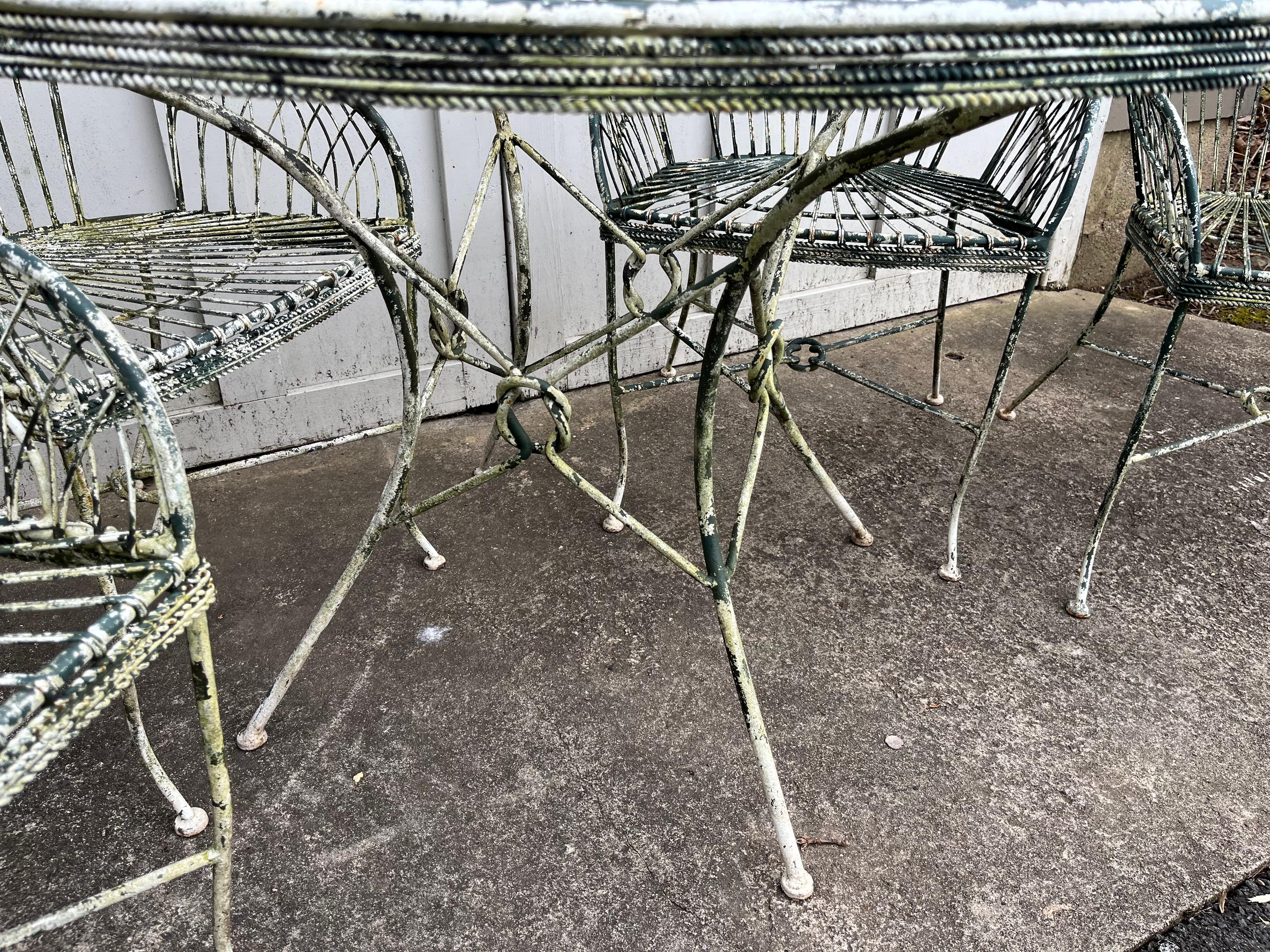 Vintage French Iron Patio Tisch mit vier Armstühlen. Reste verschiedener Farbschichten bilden eine unschätzbare Patina. Etwas rohes Metall mit grünen und weißen Farbtupfern. Wunderbar. Knoten in. Jeder Stuhl ist 321/2 Zoll hoch, 22 2 1/2 Zoll breit
