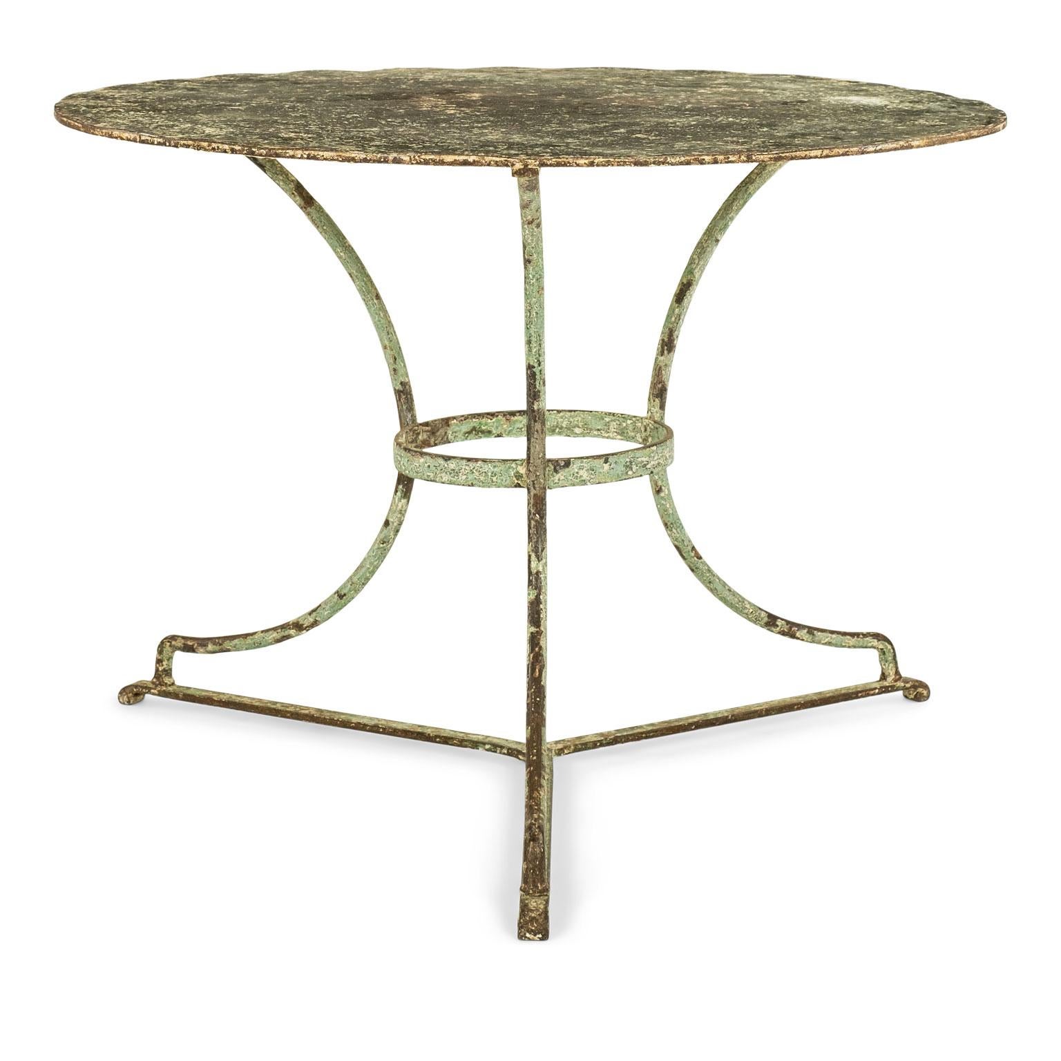 Vintage French iron round garden table circa 1920-1940: round painted steel top raised upon three-legged iron base. Remnants of old painted finish. Nice large scale.