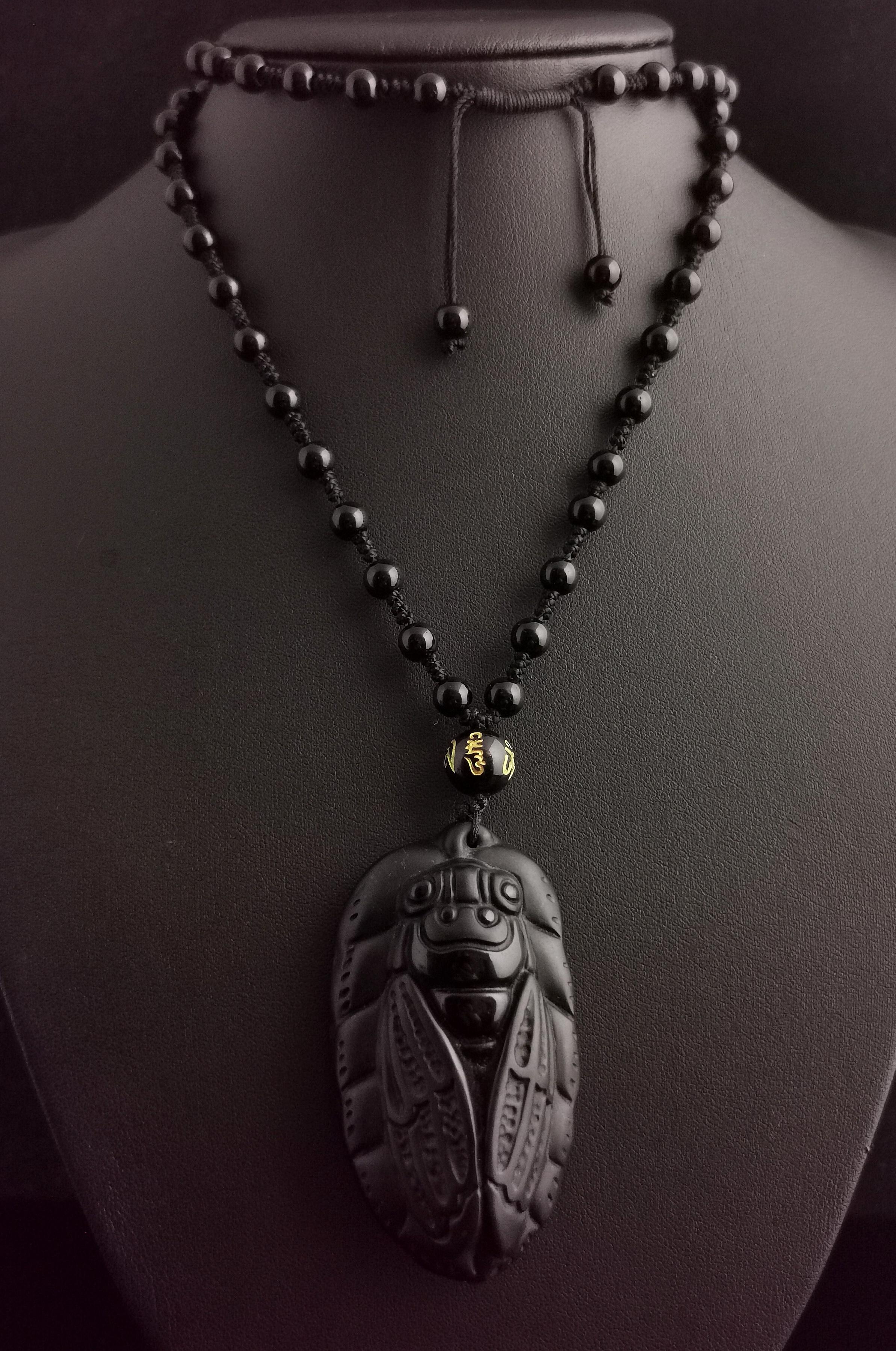 A magnificent vintage French Cicada pendant and French jet Bead necklace.

This is a substantial heavy piece made from carved stone with a matte finish to the front and a high shine polish to the reverse.

It is attached to a black cord and strung