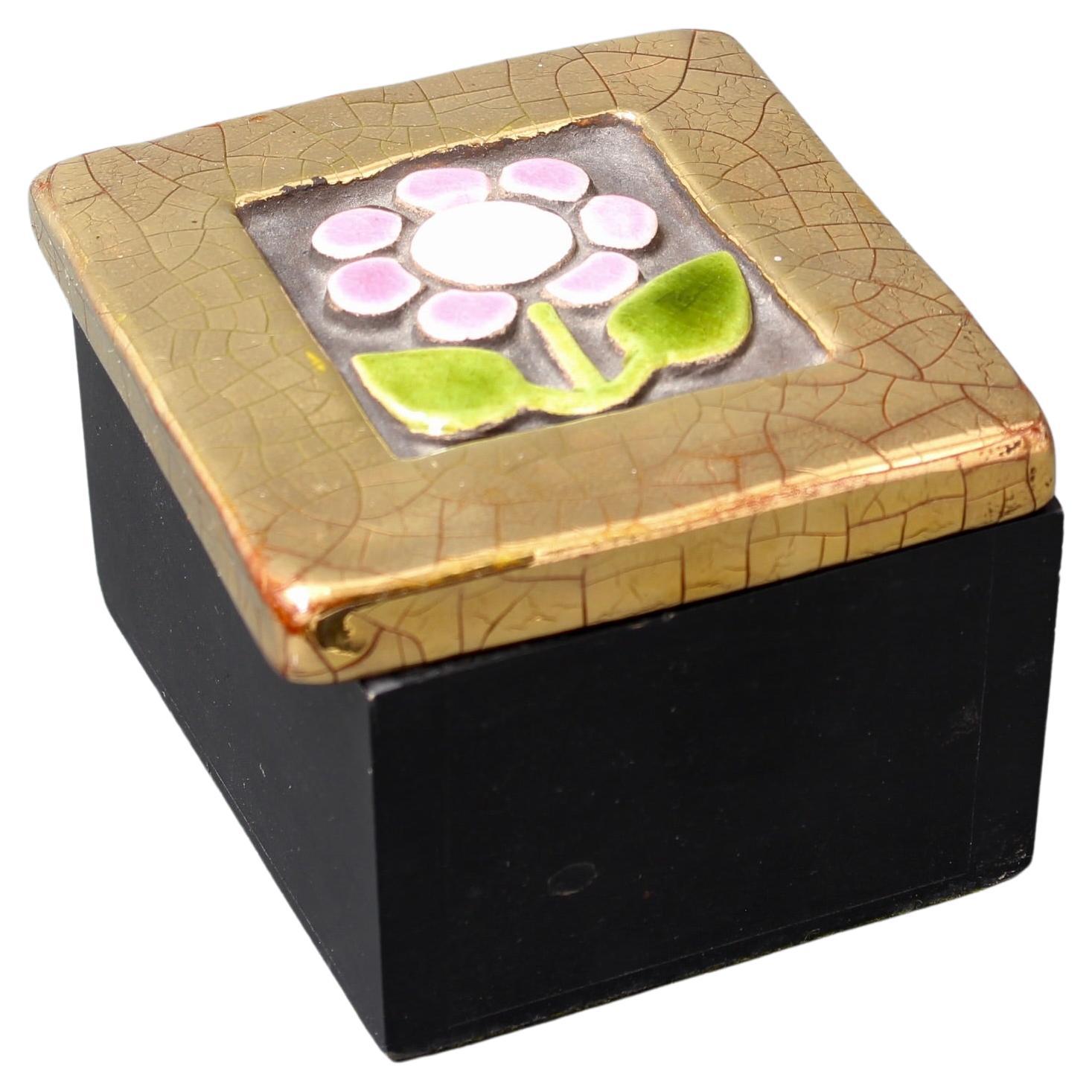Jewellery box with decorative ceramic lid by Mithé Espelt (circa 1960s). Quaint raised sunflower motif with pink, green and white over a neutral dark base backdrop. The decorative surround is in Espelt's trademark gold crackle. The lid tops a small,