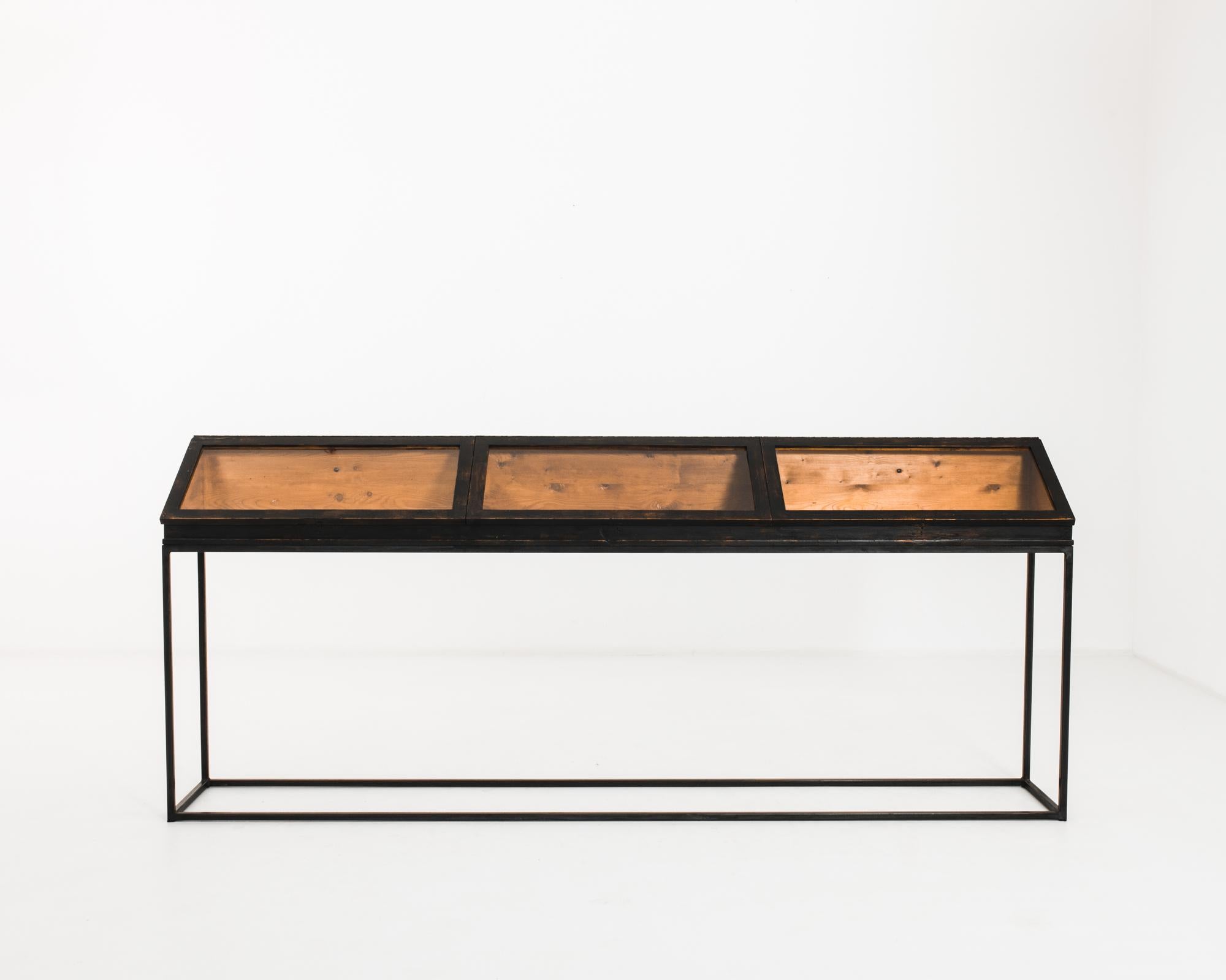 This wood and metal jewelry discounter counter was made in France, circa 1950. The angular metal base and oblique vitrine comprise the clean geometric silhouette of this Mid-Century Modern design piece. It features three compartments, easily