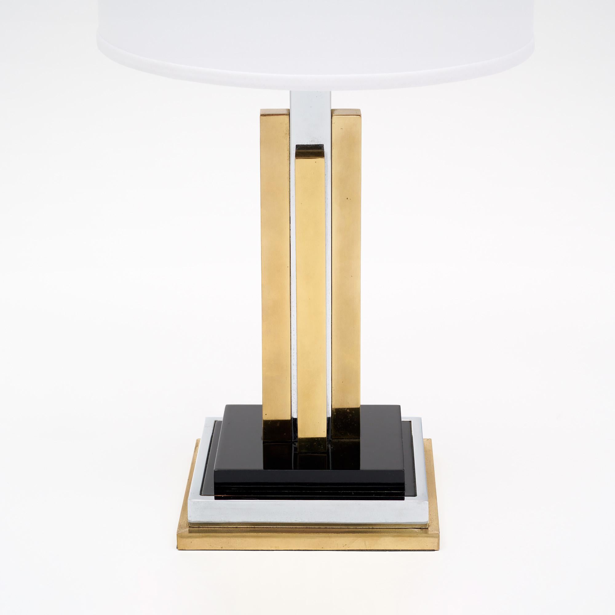 Table lamp from France in the style of Philippe Cheverny. This modernist piece mimics a stylized skyscraper with brass and chromed steel components. It sits on a black lacquered base. It has been newly wired to fit US standards. The lamp is in very