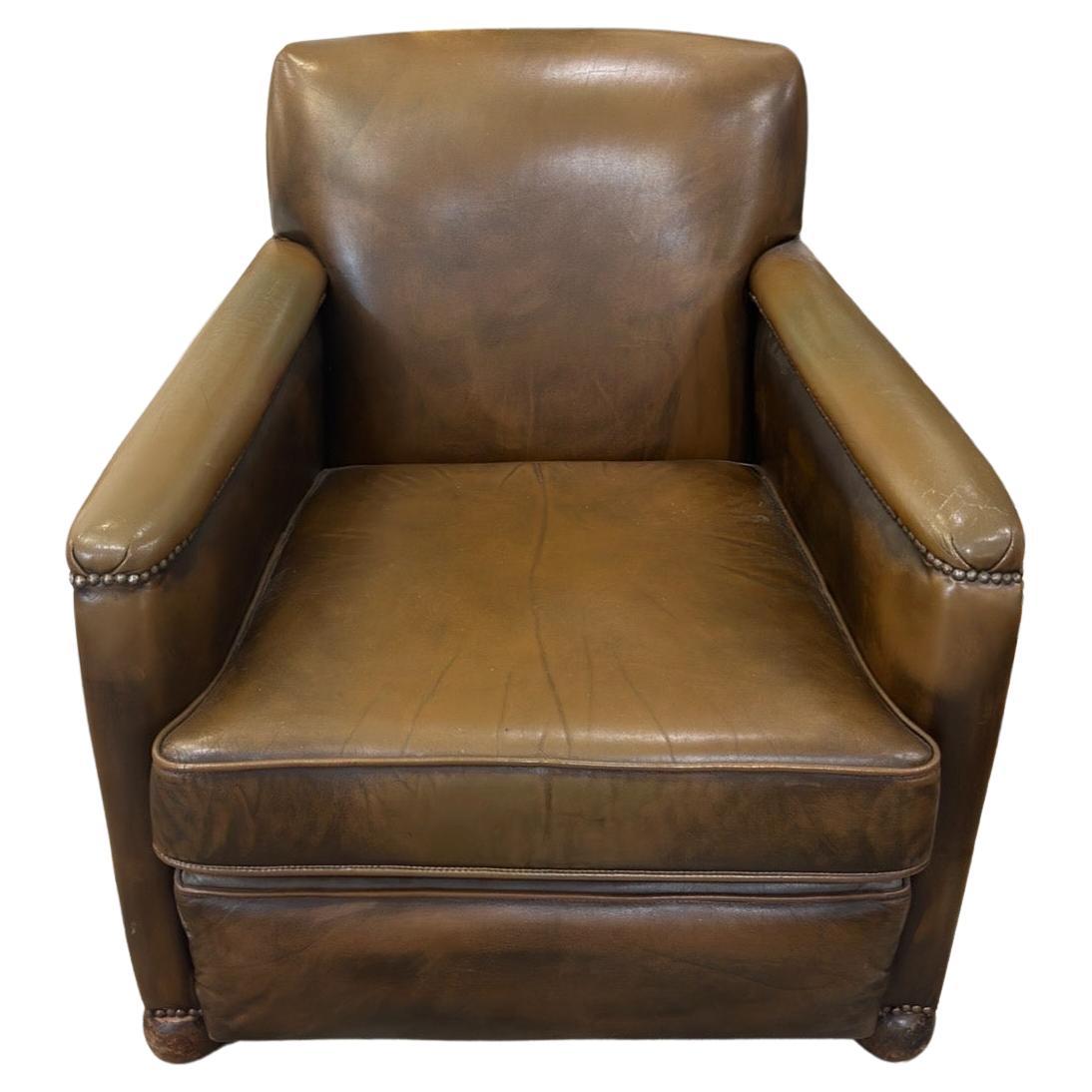 Discovered recently in Northern France, this vintage leather club chair makes for a very comfortable and stylish addition to a living or office area. Upholstered with dark brown leather and includes nailhead trim along the front. Wooden feet and