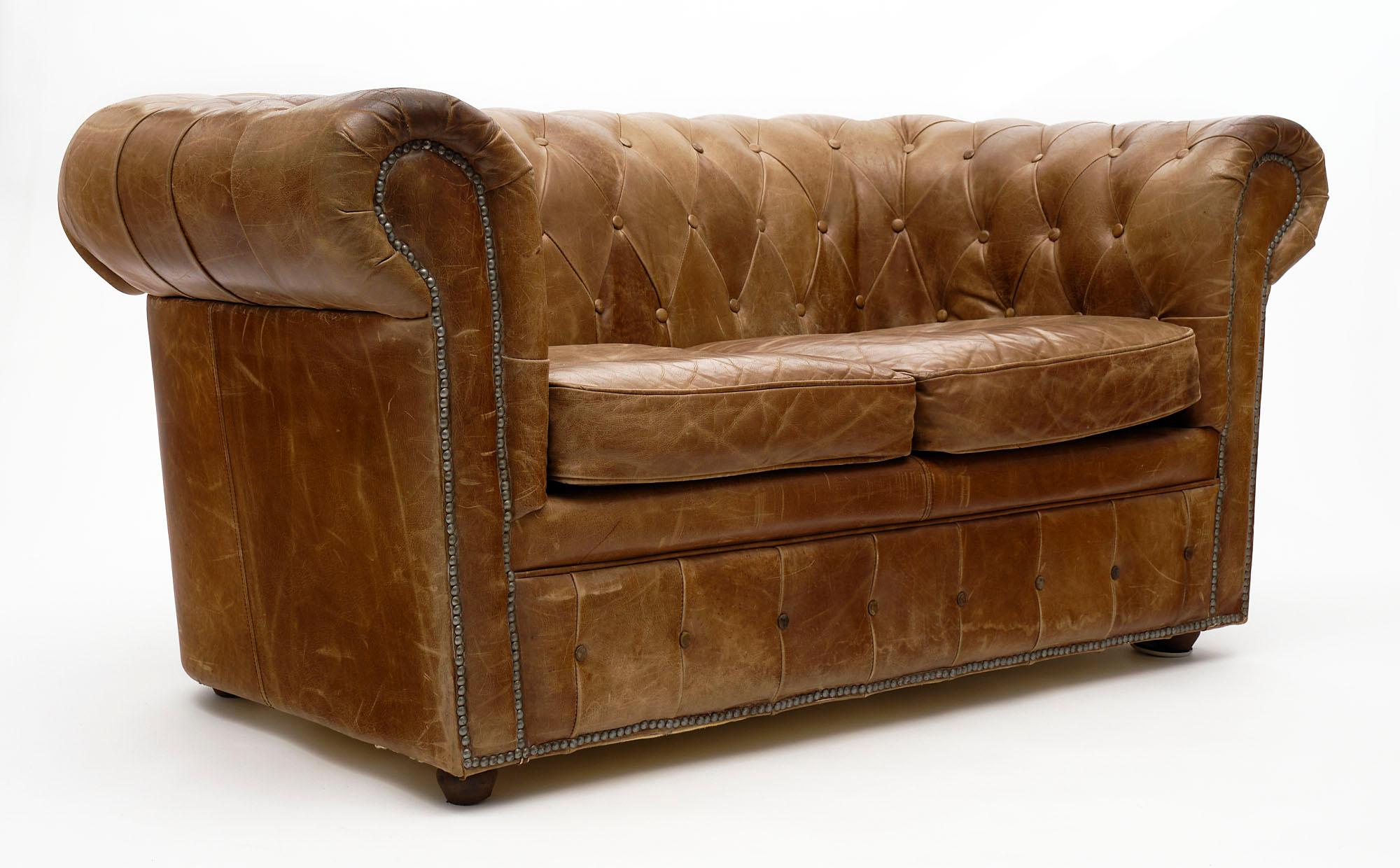 Sofa, Chesterfield, of tan natural leather, upholstered in a diamond pattern.