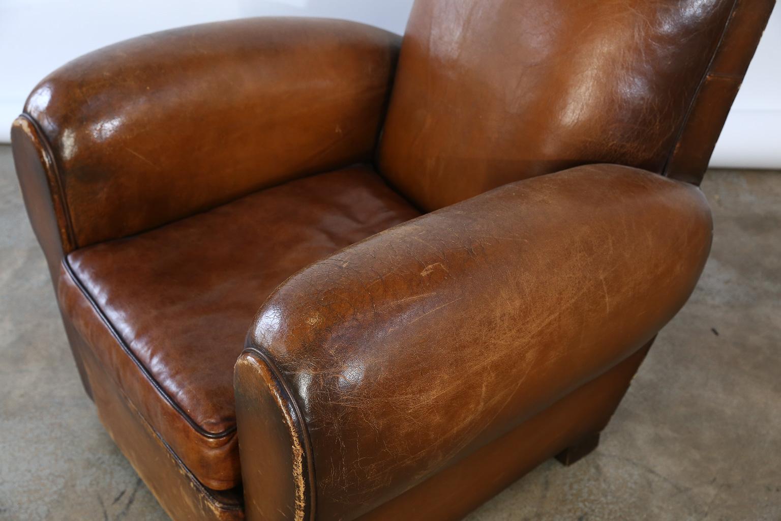 This is a beautiful Art Deco French leather club chair. The leather has a beautiful patina with wear consistent with age and use. Well used and loved for many years, the club chair boasts both style and character.