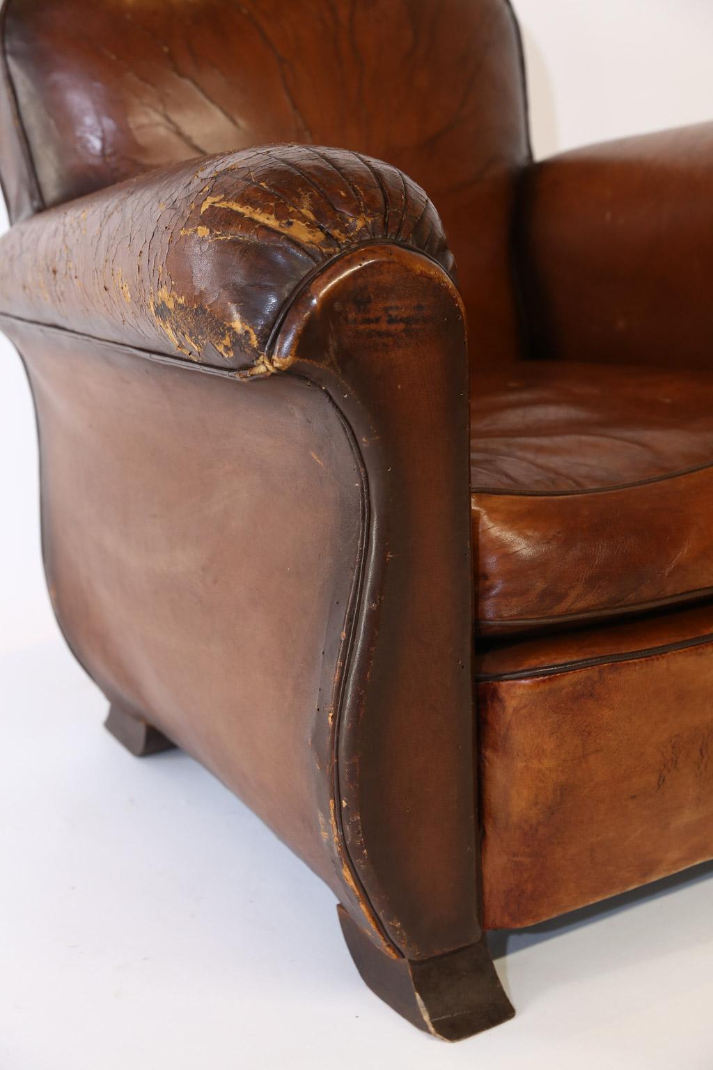 This is a beautiful French leather club chair. The leather has a wonderful patina with wear consistent with age. Well used and loved for many years, the club chair boasts both style and character.