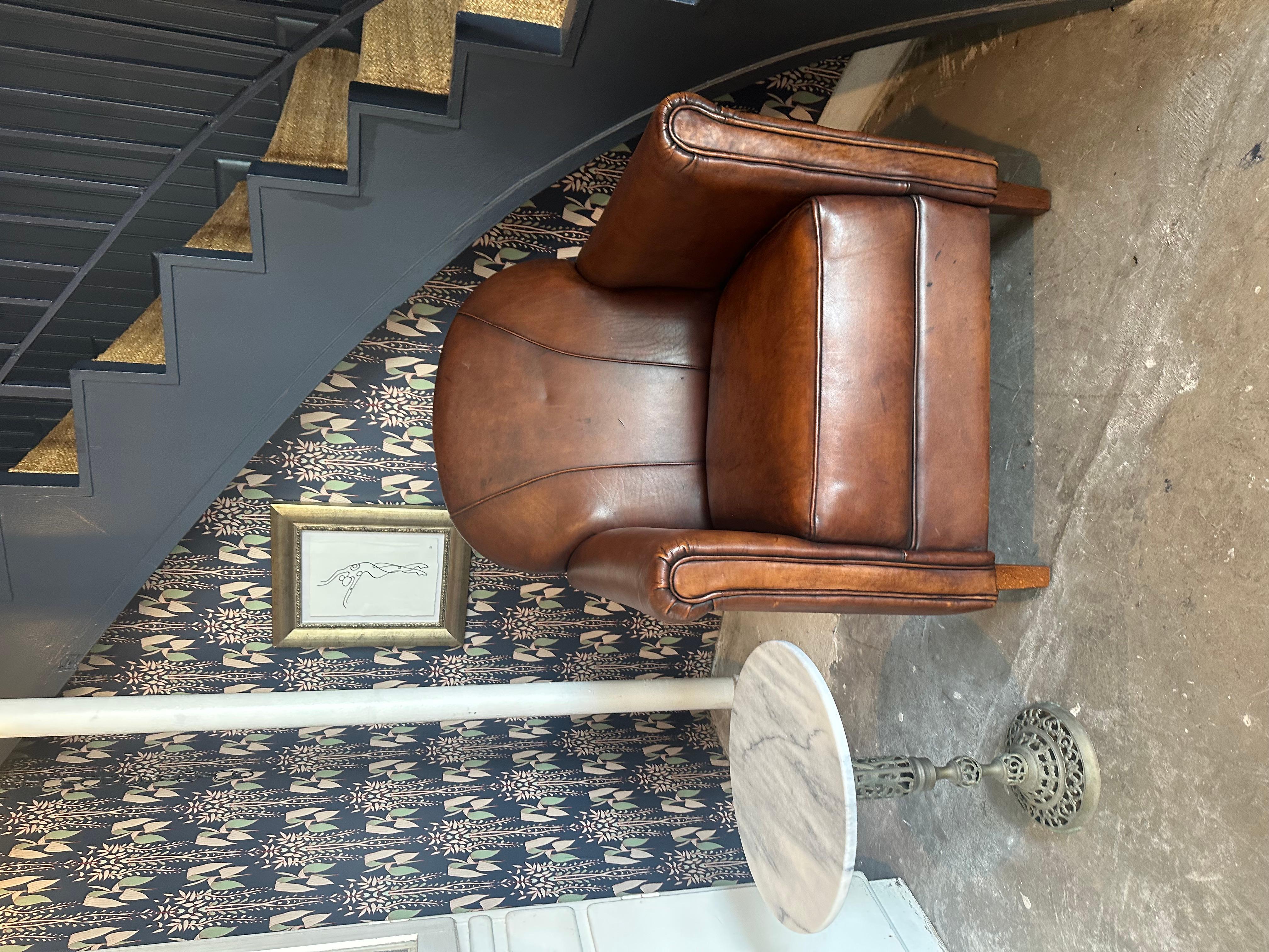 Sink into timeless comfort with this Vintage French Leather Club Chair. Upholstered in rich, patinated leather with classic rolled arms and a rounded back, it exudes understated elegance and warmth. A perfect accent for cozy reading nooks, stylish