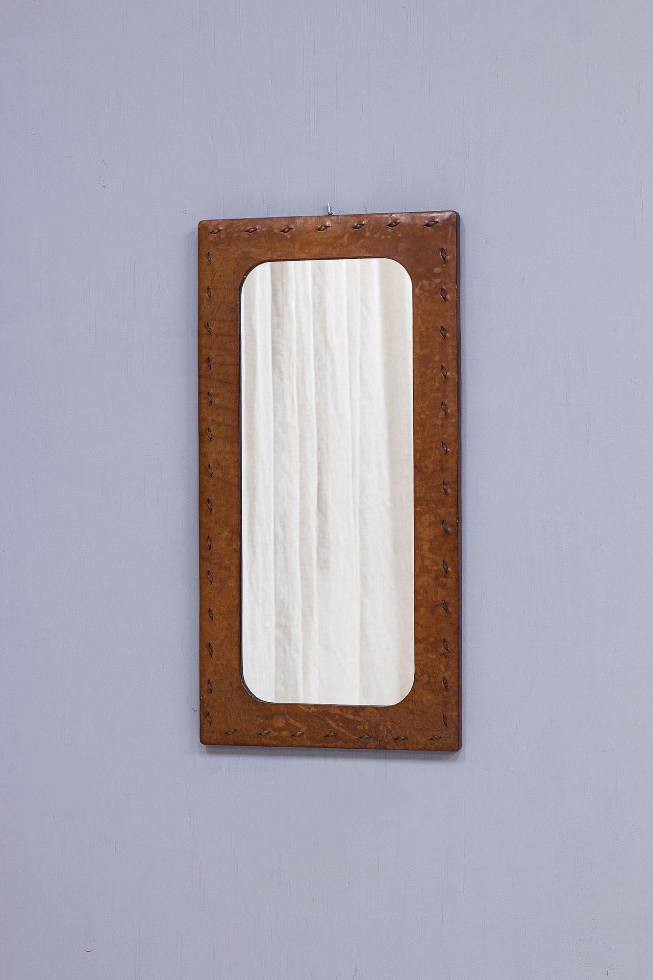 Step back in time with this charming French wall mirror from the 1950s, enveloped in a leather embrace. The mirror exudes a unique vintage charm that instantly adds character to any space.
Crafted with care, this mirror features an unknown signature