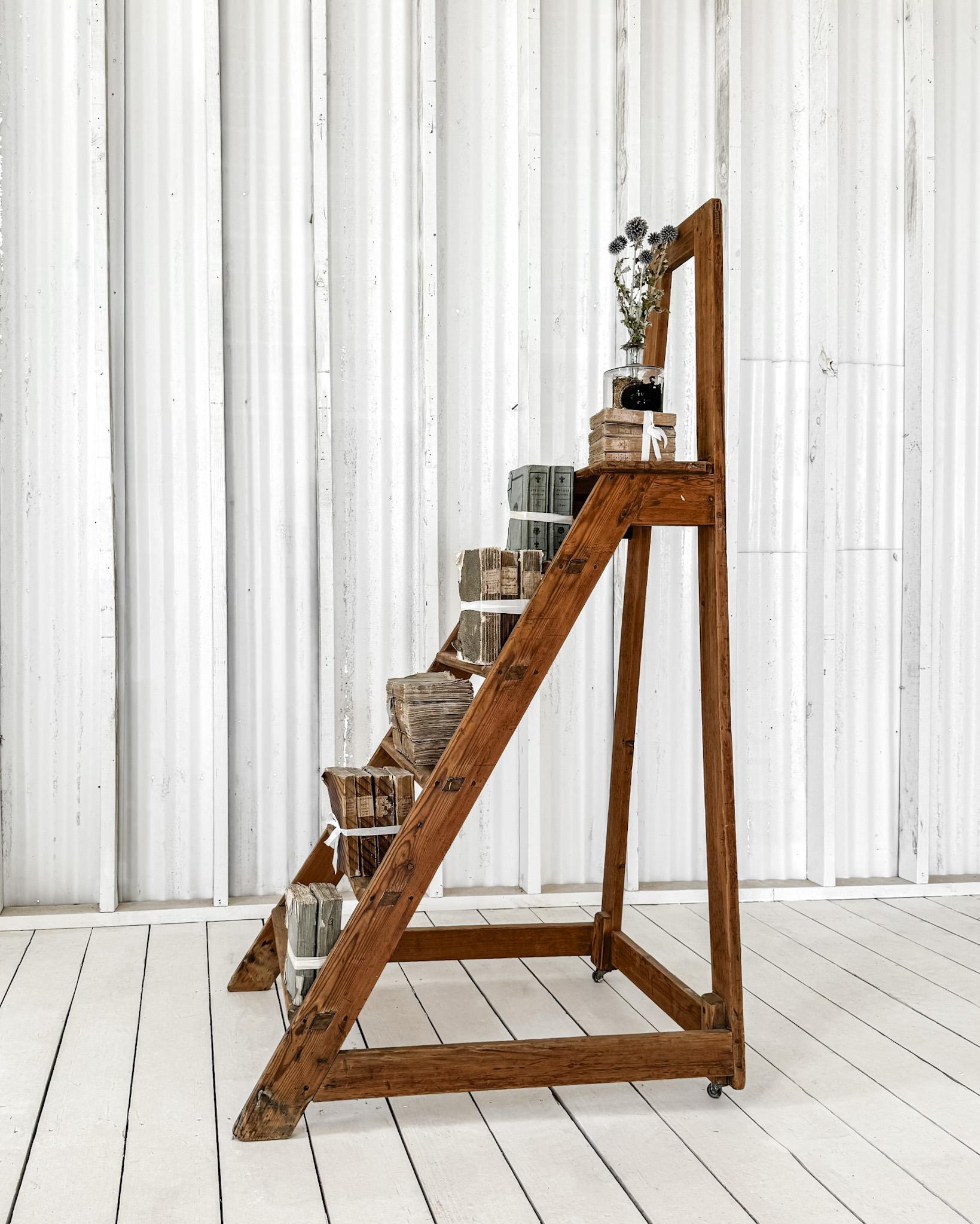 Ein hübscher Satz antiker französischer Bibliothekstreppen. Die aus Obstholz gefertigte Leiter hat ein einfaches Design und besteht aus 5 Stufen mit einer tieferen oberen Plattform. Zwei kleine Rollen an der Rückseite verbessern die Beweglichkeit