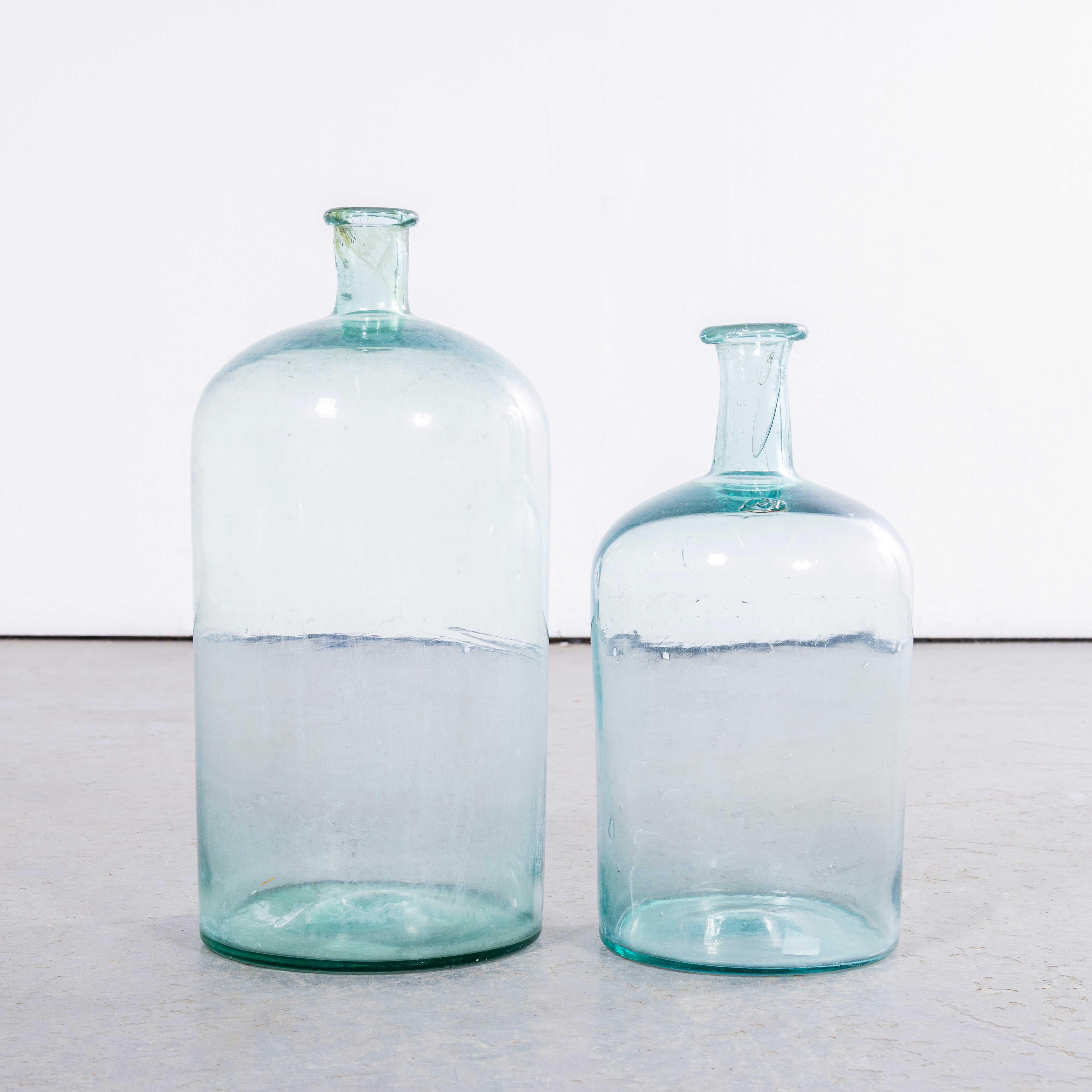 Damigiane francesi d'epoca in vetro blu e verde chiaro - Coppia. 

Una coppia di damigiane in vetro soffiato a bocca utilizzate come contenitori tradizionali principalmente per la conservazione e il trasporto del vino. Queste damigiane sono state
