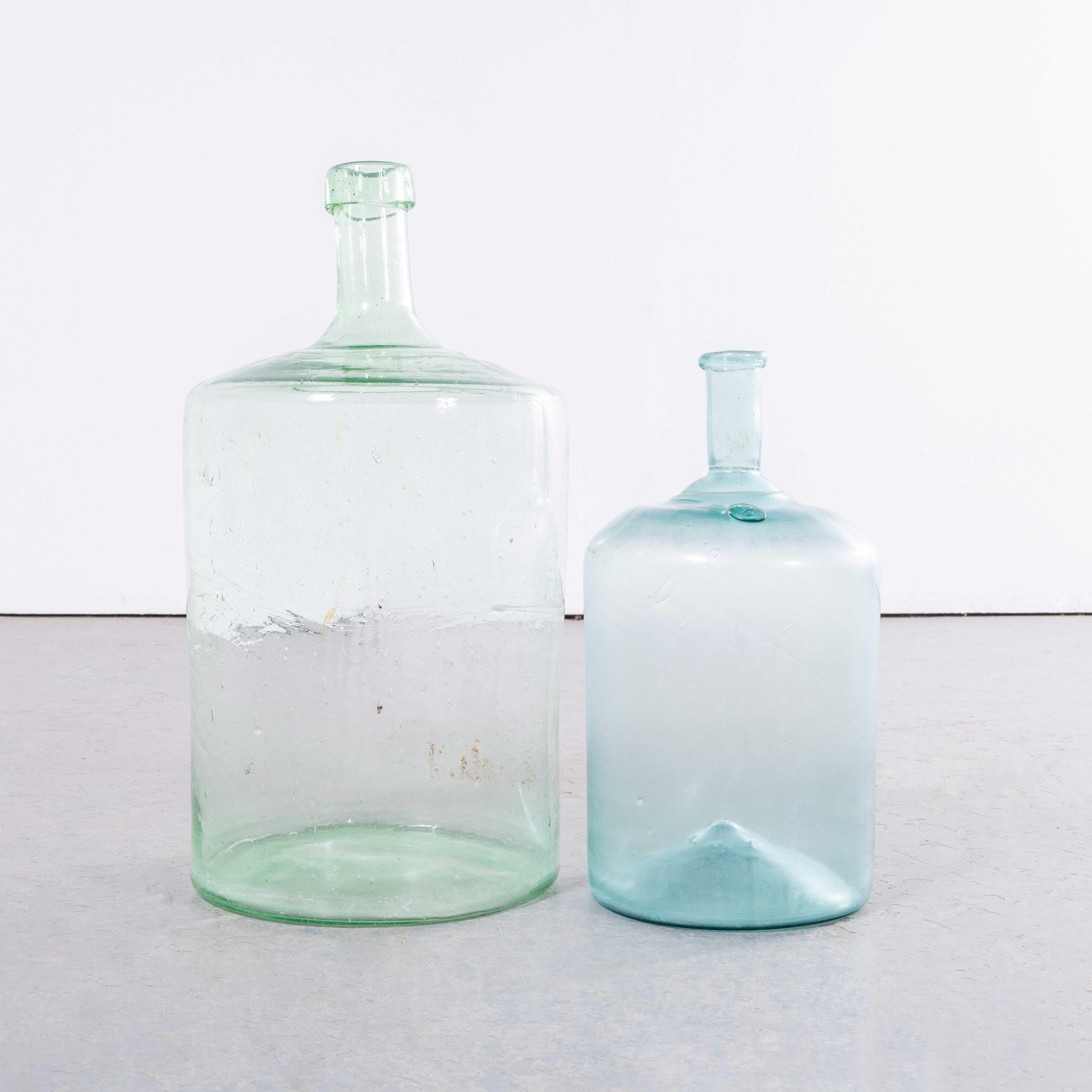 Damigiane francesi d'epoca in vetro verde chiaro e azzurro - Coppia. 

Una coppia di damigiane in vetro soffiato a bocca utilizzate come contenitori tradizionali principalmente per la conservazione e il trasporto del vino. Queste damigiane sono