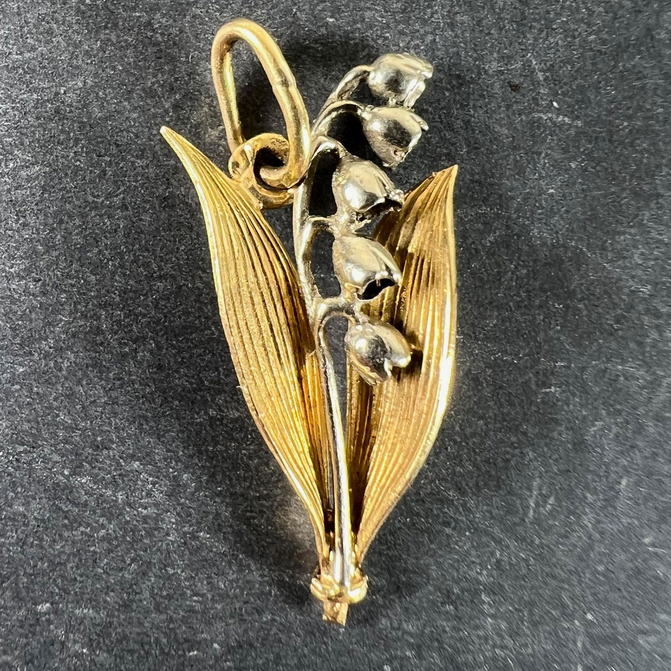 Pendentif vintage français en or jaune et blanc 18 carats (18K) conçu comme une fleur de muguet avec des feuilles. Le muguet symbolise la pureté, la joie, l'amour, la sincérité, le bonheur et la chance. Estampillé de la marque de la tête d'aigle