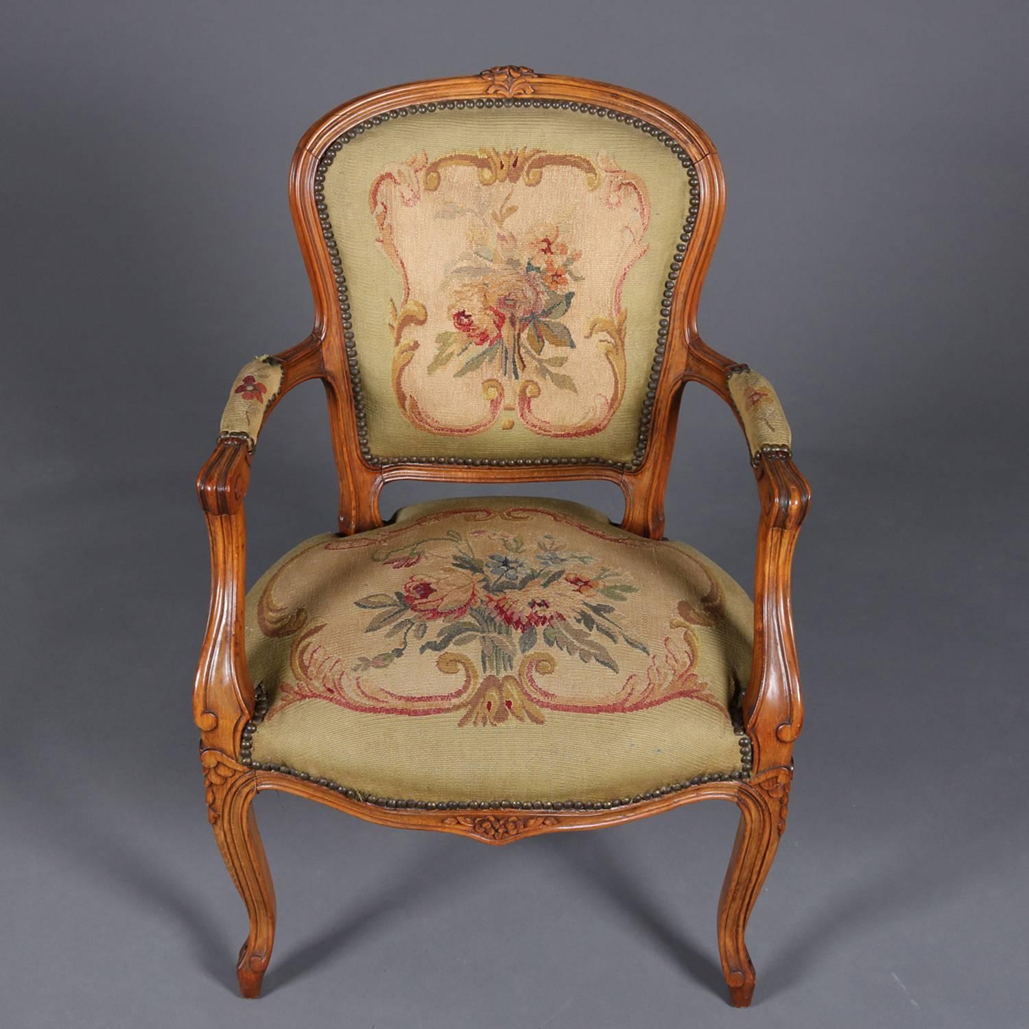 Vintage French Louis XV classical style upholstered Fauteuil armchair features carved maple frame with scroll arms and cabriole legs, tapestry with central design of European hand tied floral bouquet and scroll bordering on back and seat, circa