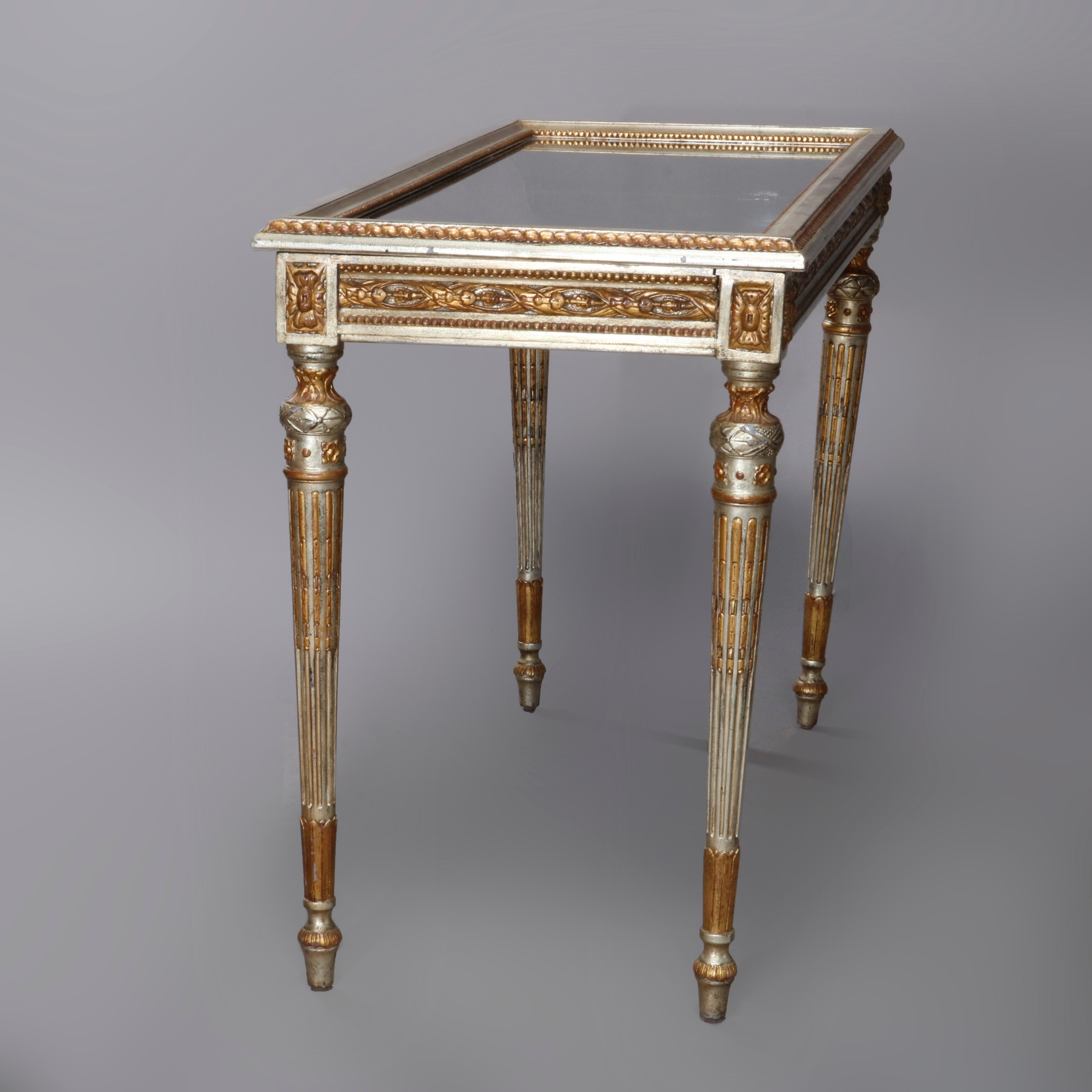 A vintage French Louis XV table virine offers silver and gold giltwood construction with glass top lifting to ebonized black lacquer display, case with foliate carved band and rosette corners, raised on reeded fluted legs having acanthus capitals,