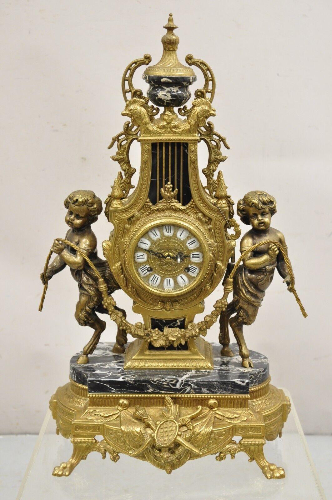 Vintage French Louis XV Style Brevetatto Italy Brass & Marble Figural Clock Set - 3 Pc Set. Item features an ornate figural clock with hoof foot cherubs and black marble accents, 2 ornate candelabras with 7 candle holders and cherub heads. German