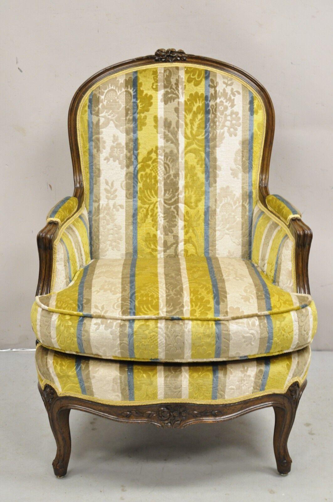 Vintage French Louis XV Style Carved Walnut Upholstered Bergere Lounge Arm Chair. L'article présente un revêtement imprimé bleu, jaune et beige, un cadre finement sculpté et vieilli, un dossier soutenu par un châssis, une très belle chaise vintage.