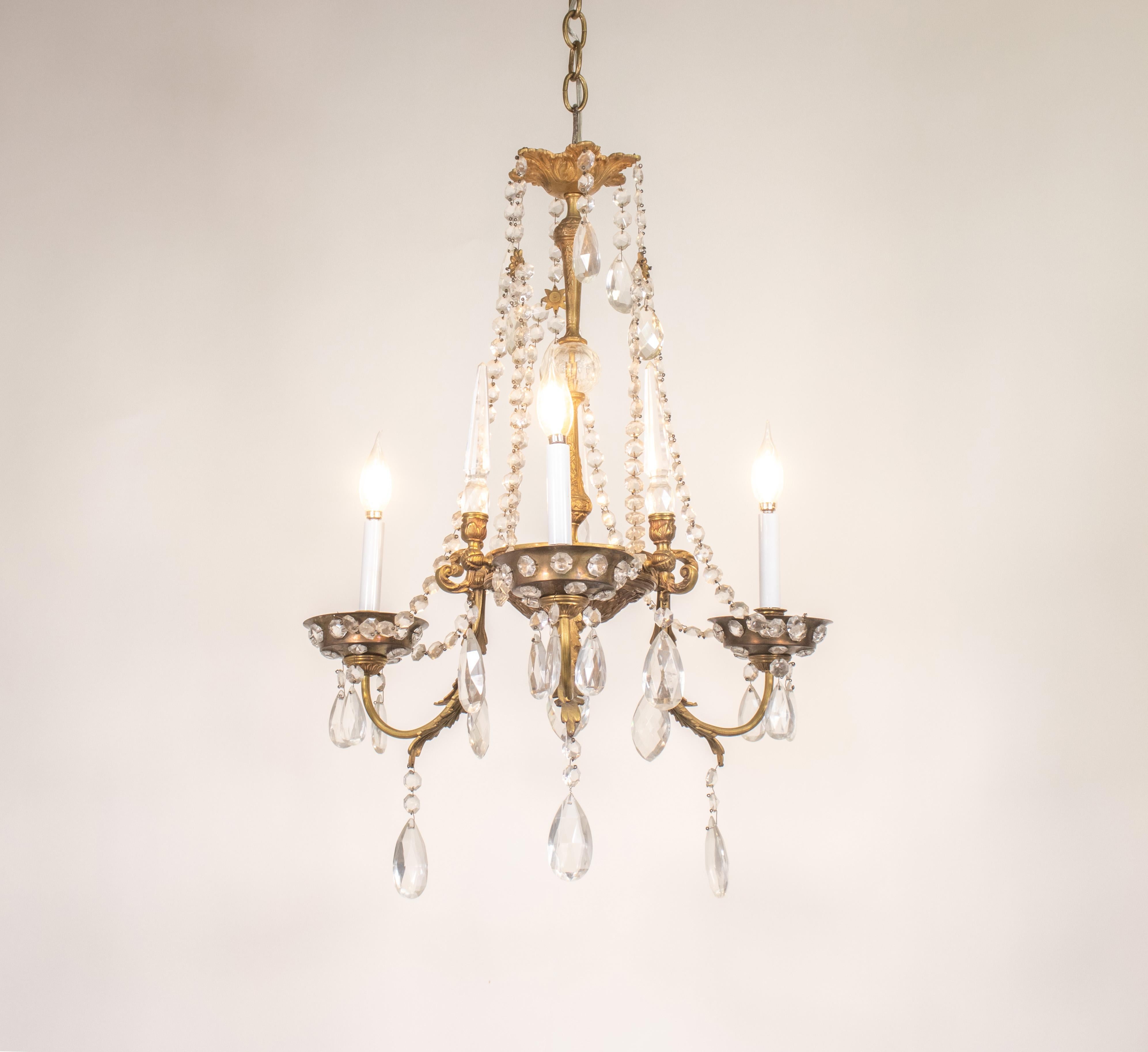 Ce lustre en cristal de style Louis XV est une pièce en bronze doré coulée à la main, avec une combinaison de bronze pour le corps et les bras, et de laiton pour les bouquets, réalisée dans le style de la Maison Jansen.

La Maison Gaines, célèbre