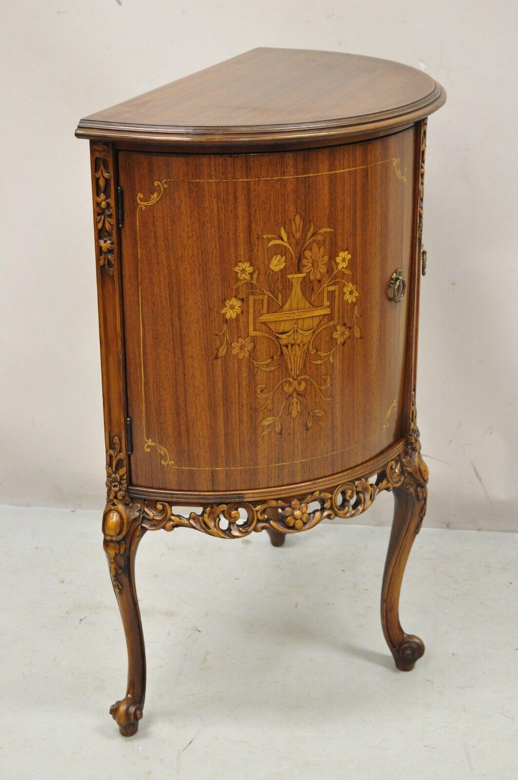 Vieille table d'appoint demi-ronde de style Louis XV avec 2 portes, incrustation florale. L'article présente une forme demilune demi-ronde, une urne en bois de satin et une incrustation florale, 2 portes battantes, des pieds cabriole. Vers le début