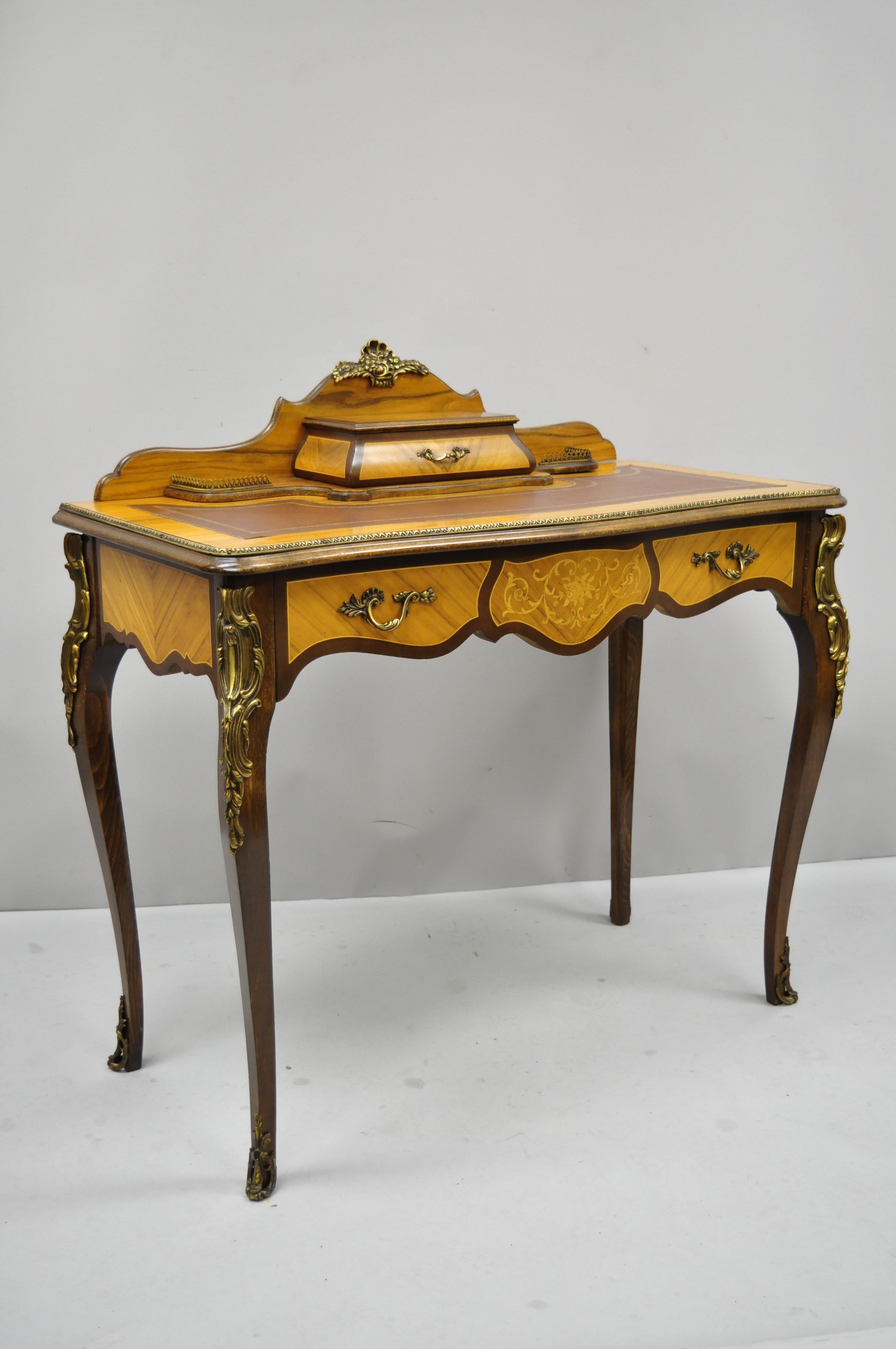 Vintage French Louis XV style inlaid leather top petite ladies writing desk. Item features floral inlay, brass ormolu, beautiful wood grain, 2 dovetailed drawers, cabriole legs, very nice vintage item, great style and form, circa mid-20th century.