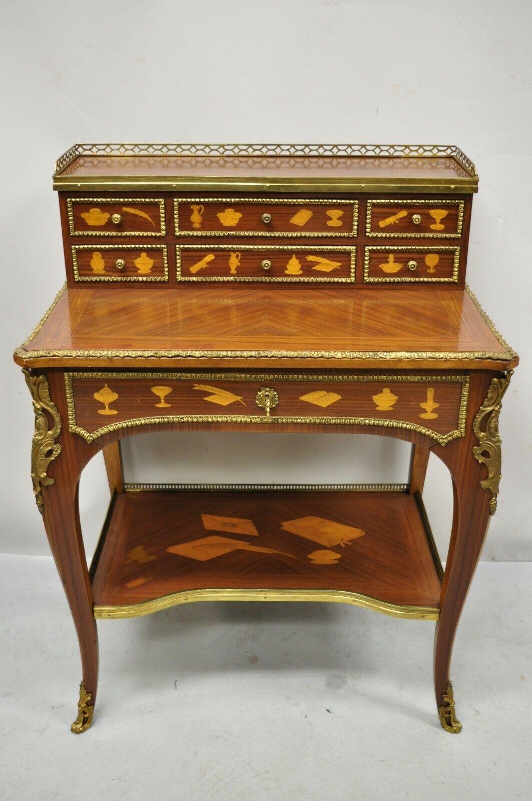 Vintage French Louis XV style marquetry inlay bronze ormolu small writing desk. Item features ornate bronze ormolu, lower shelf with inlaid desk set, satinwood floral inlay throughout, beautiful wood grain, 7 drawers, very nice vintage item, great