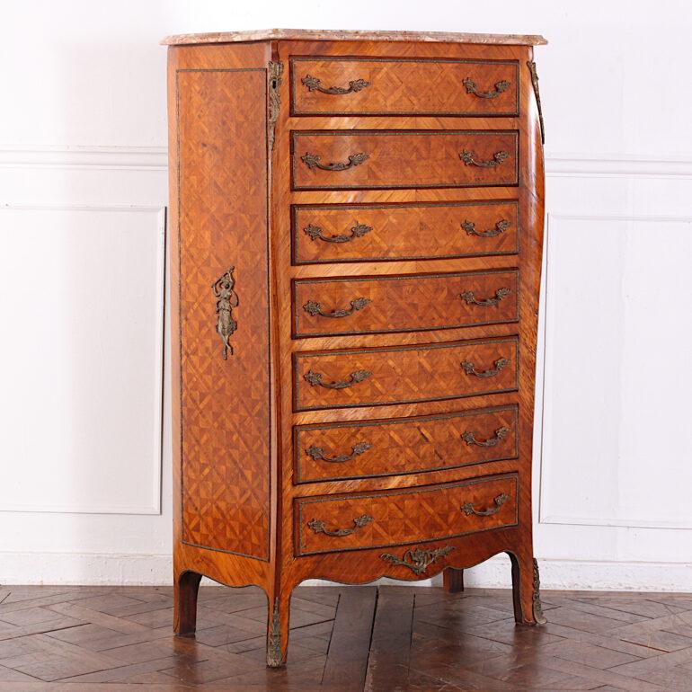 Vintage French Louis XV style marble-top semainier or seven-drawer chest, the serpentine profile case with parquetry veneer and accented with gilt mounts. Original shaped marble top. 

