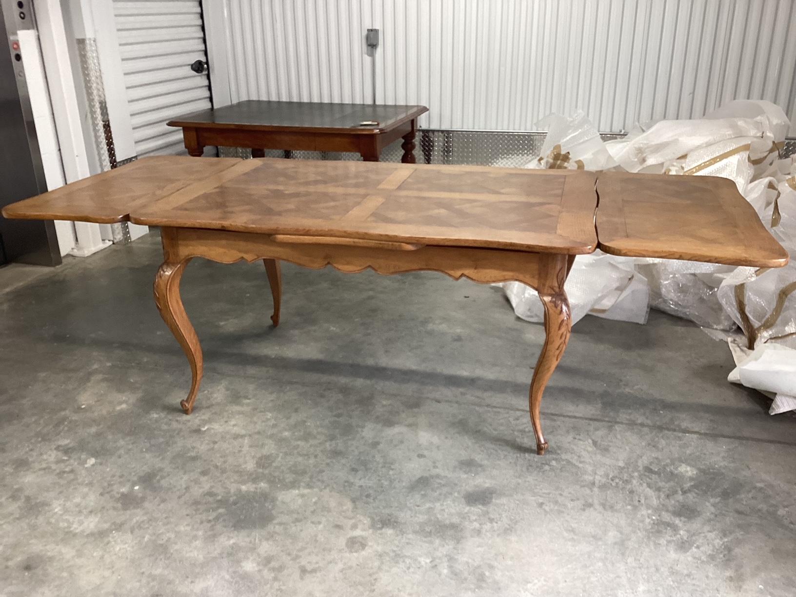 Exceptional French Louis XV style dining table having light oak parquet top and delicate cabriole legs.
Imported from France, this table opens with 2 leaves and extends to 97