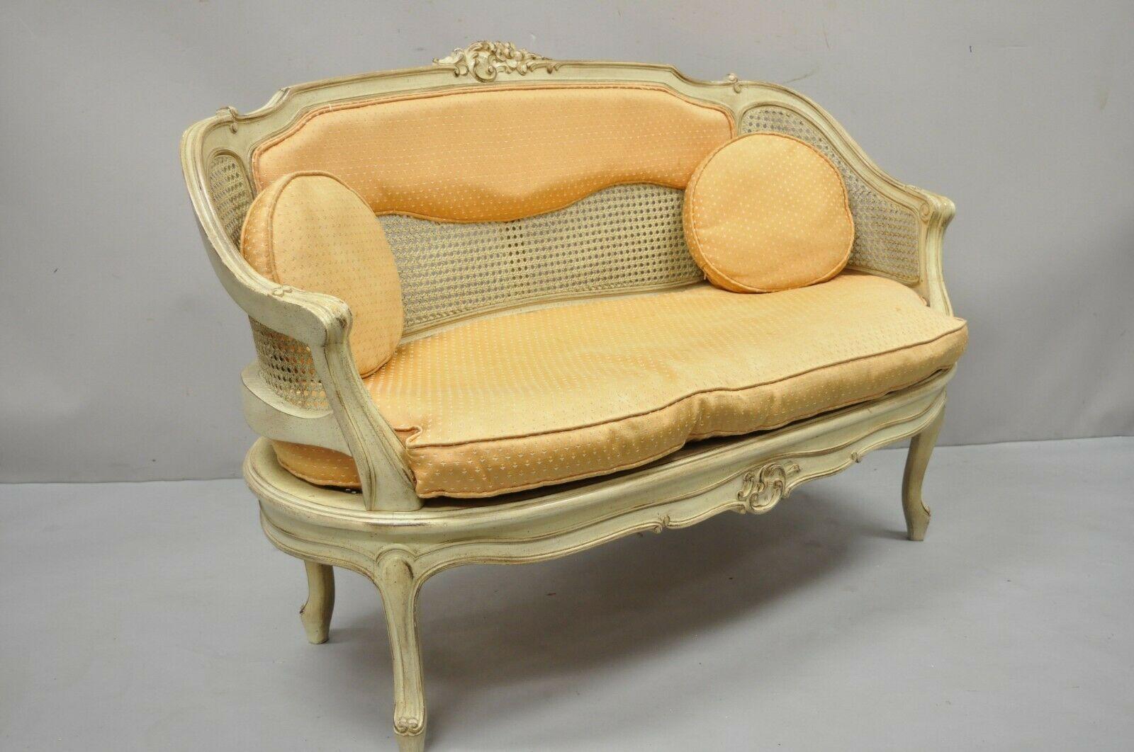 Vintage French Louis XV Victorian Style Small Cane Cream Settee Loveseat Sofa. Der Stuhl hat eine Rückenlehne und einen Sitz aus Schilfrohr, ein loses Kissen, eine cremefarbene Lackierung, einen Rahmen aus Massivholz, Cabriole-Beine, einen sehr