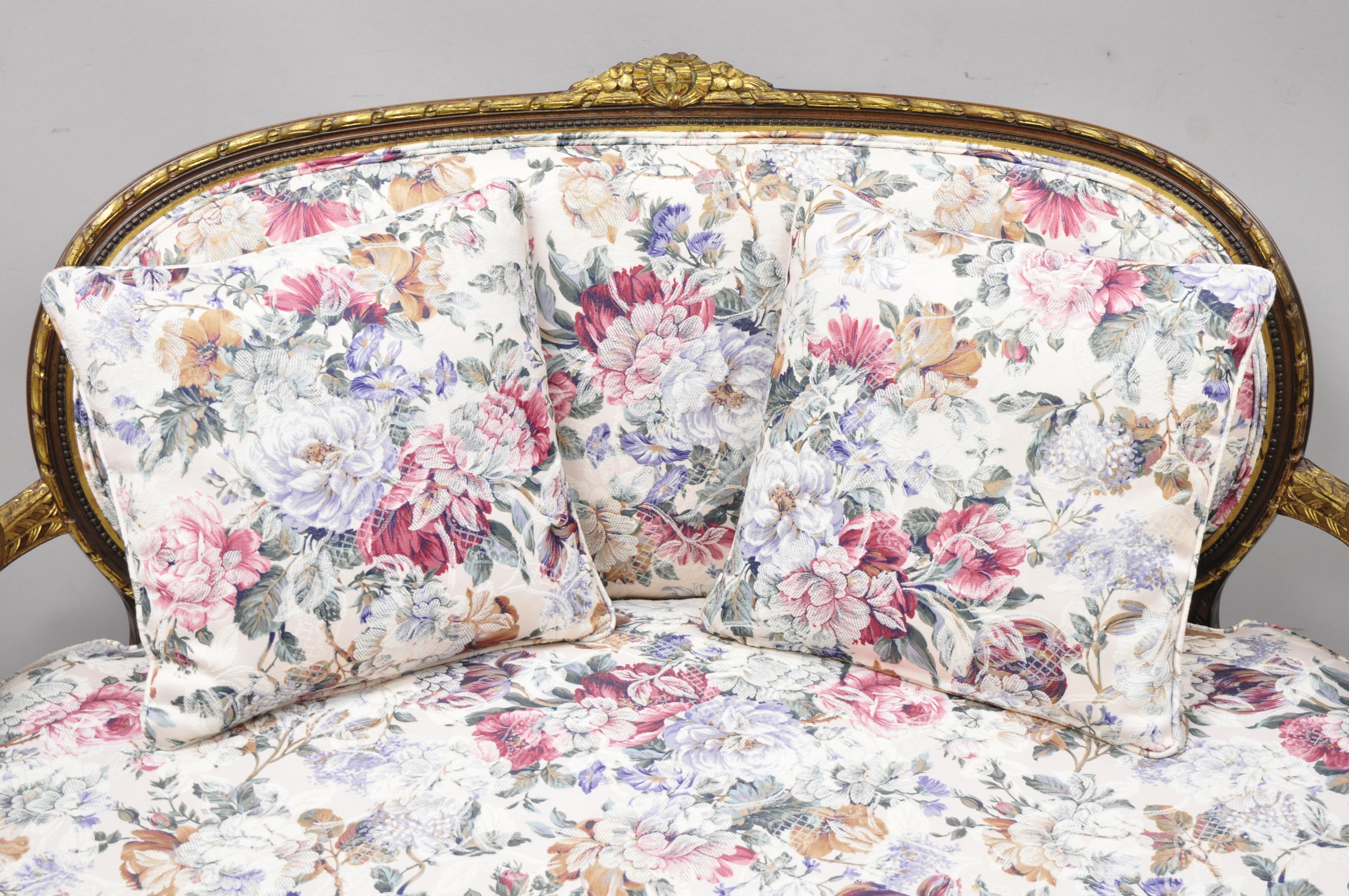 Vintage French Louis XVI gold giltwood floral upholstered loveseat settee sofa. Item features gold gilt accents, (2) loose pillows, floral fabric, solid wood frame, upholstered armrests, nicely carved details, tapered legs, very nice vintage item,