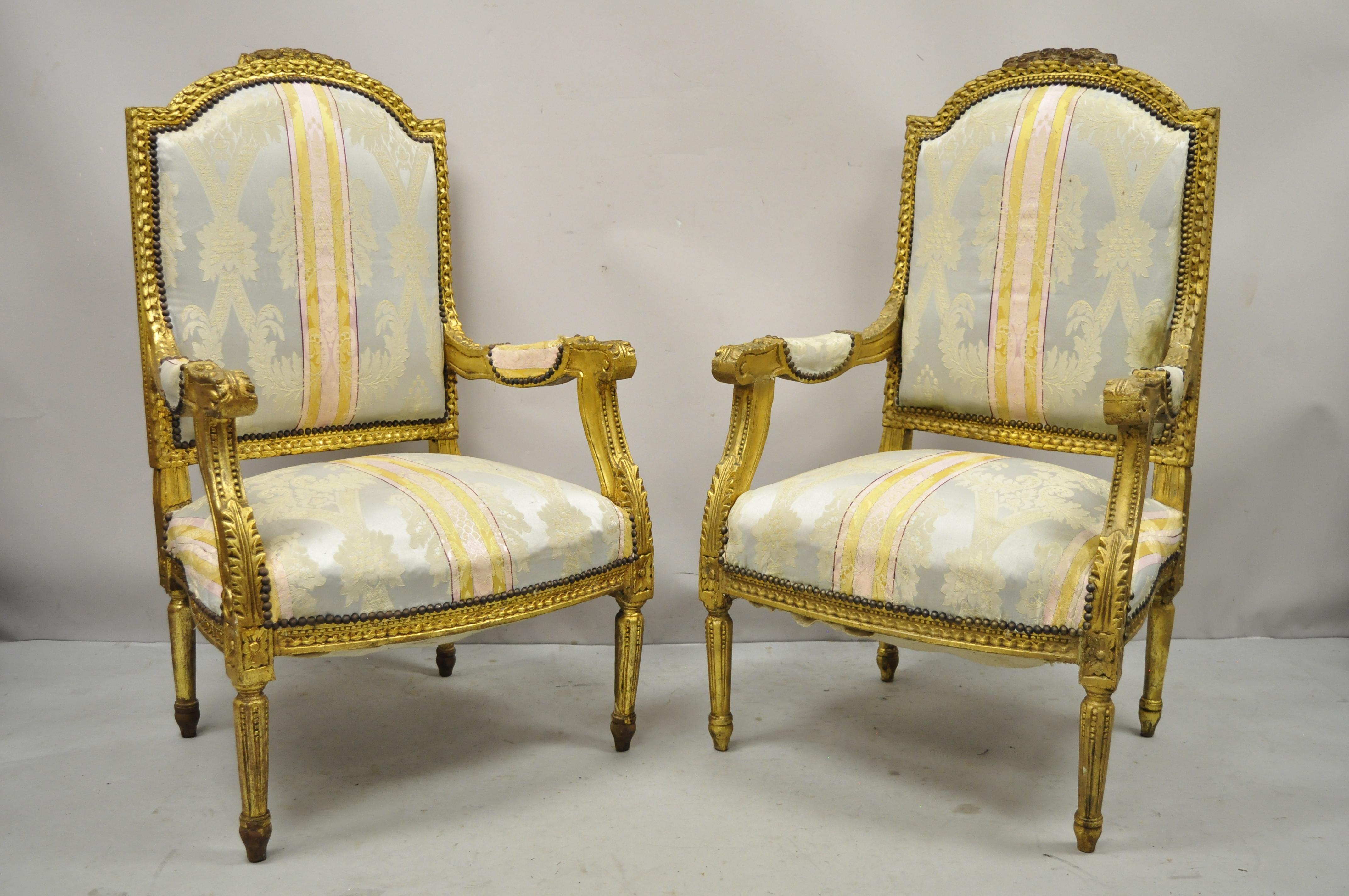 Vintage French Louis XVI carved gold Giltwood upholstered lounge arm chairs (B) - a Pair. Item features distressed gold gilt finish, floral carved details, solid wood frames, tapered legs, great style and form. Circa Late 20th Century. Measurements: