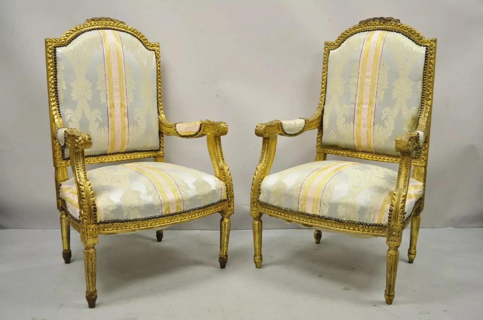 Vintage French Louis XVI Gold Giltwood Upholstered Lounge Chairs (B) - una coppia. L'articolo è caratterizzato da una finitura dorata e distorta, dettagli floreali intagliati, cornici in legno massiccio, gambe affusolate, grande stile e forma. Circa