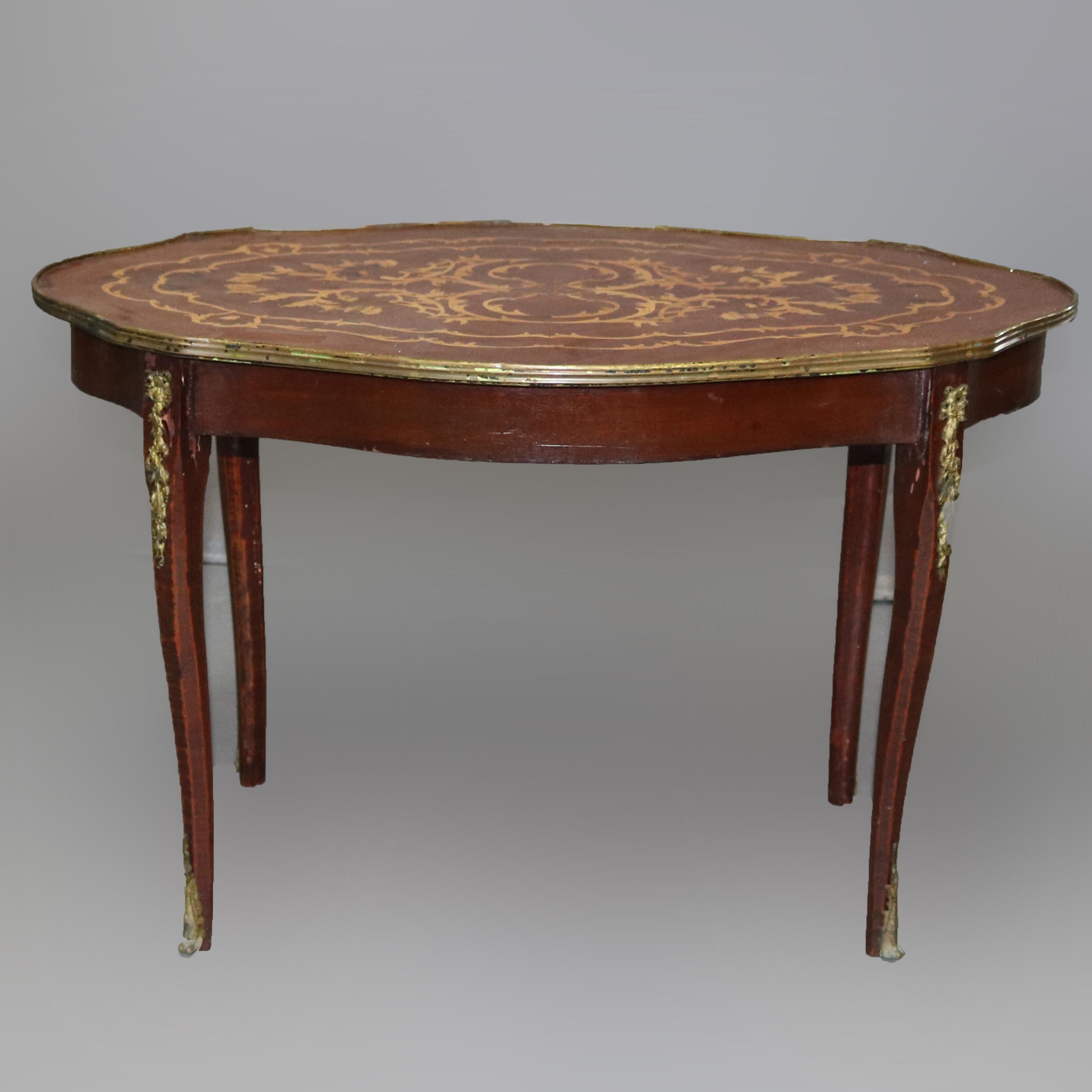 Vintage French Louis XVI style coffee table offers mahogany construction with shape top having scroll and foliate satinwood marquetry with bronze band raised on cabriole legs with foliate ormolu, reminiscent of Dutch marquetry, 20th century.