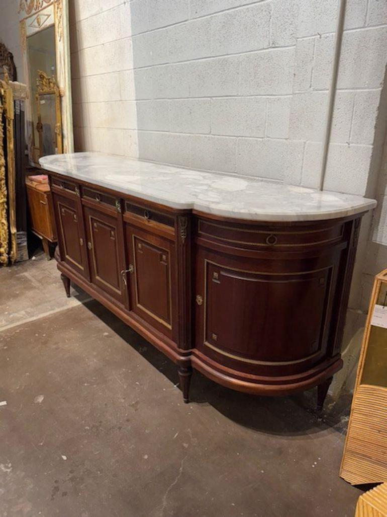 Dieses Vintage Louis XVI Mahagoni Sideboard mit Marmorplatte ist ein klassisches antikes Möbelstück, das Eleganz und Raffinesse ausstrahlt. Diese Anrichte aus luxuriösem Mahagoni mit einer beeindruckenden Marmorplatte ist ein zeitloser Schatz, der