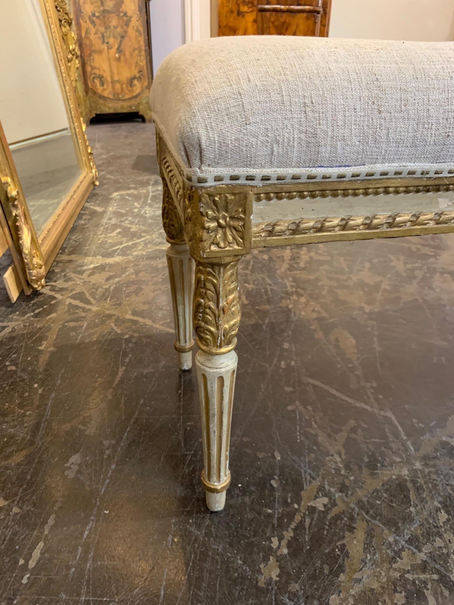 Gorgeous vintage French Louis XVI style carved and parcel-gilt bench. Upholstered in a beautiful linen fabric. A stylish accessory that mixes with a variety of decors!