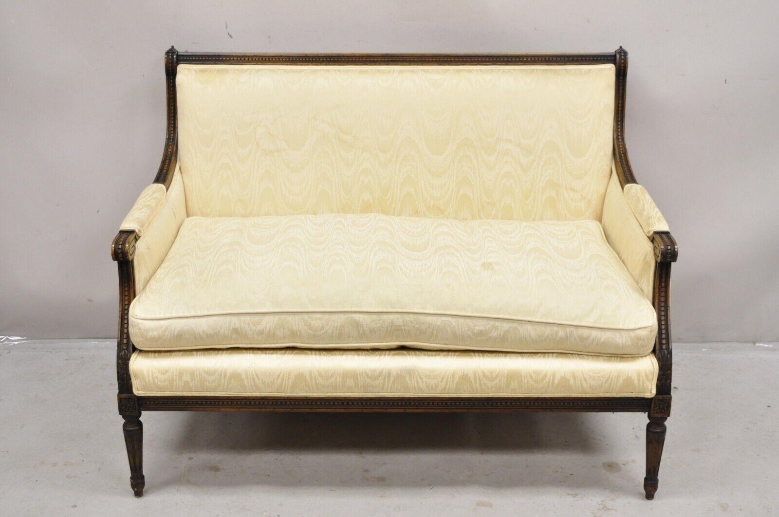 Vintage French Louis XVI Style Carved Walnut Upholstered Settee Loveseat Sofa. Item features carved wood distressed finish, tapered legs, pointed finials, very nice vintage settee. Circa Mid 20th Century. Measurements: 35