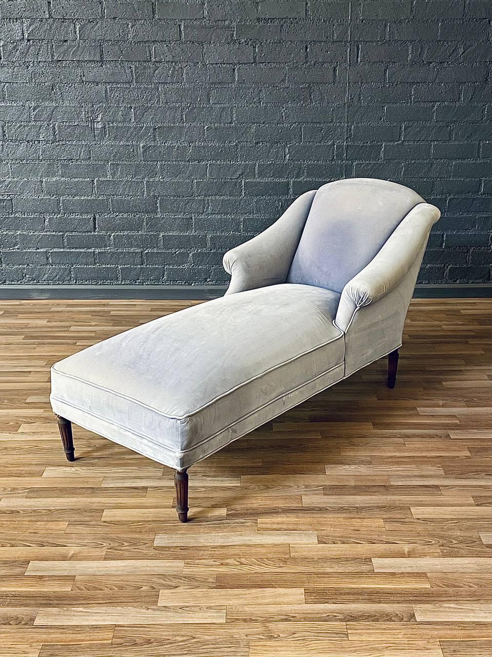 Elevate your space with this Vintage French Louis XVI Style Chaise Lounge, crafted in the 1950s. This elegant piece features a gracefully sloped backrest, rolled arms, and fluted mahogany legs, embodying the timeless sophistication of Louis XVI