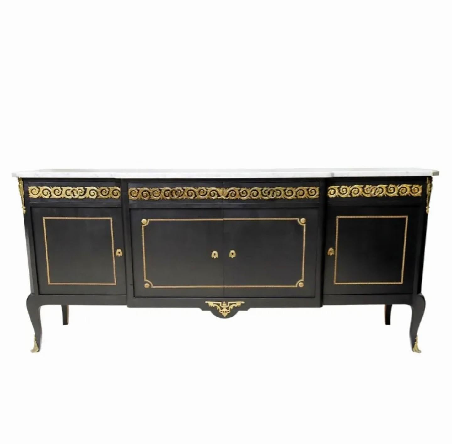 A spectacular French Louis XVI style ebonized sideboard in the manner of famous Parisian designer Maison Jansen, finely hand-crafted by NF Ameublement in France in the mid-20th century, having breakfront shaped marble top, over conforming case