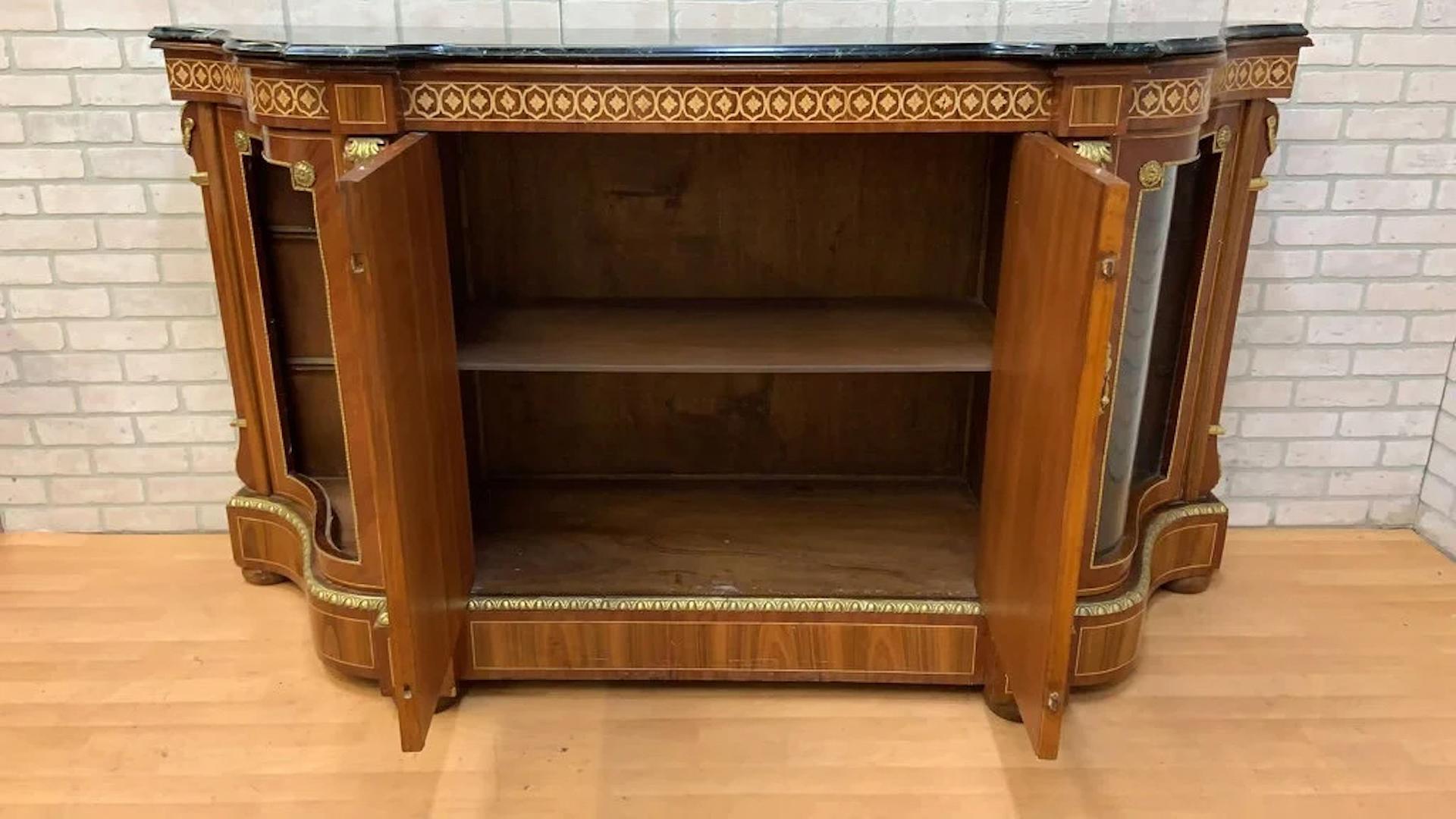 Vintage French Louis XVI Style Inlaid Serpentine Marble Top Credenza 

This gorgeous ornate French Louis XVI Style inlaid credenza has intricate inlay work and metal decorations. Behind its two main doors in a two-tiered shelf, and on each side is a