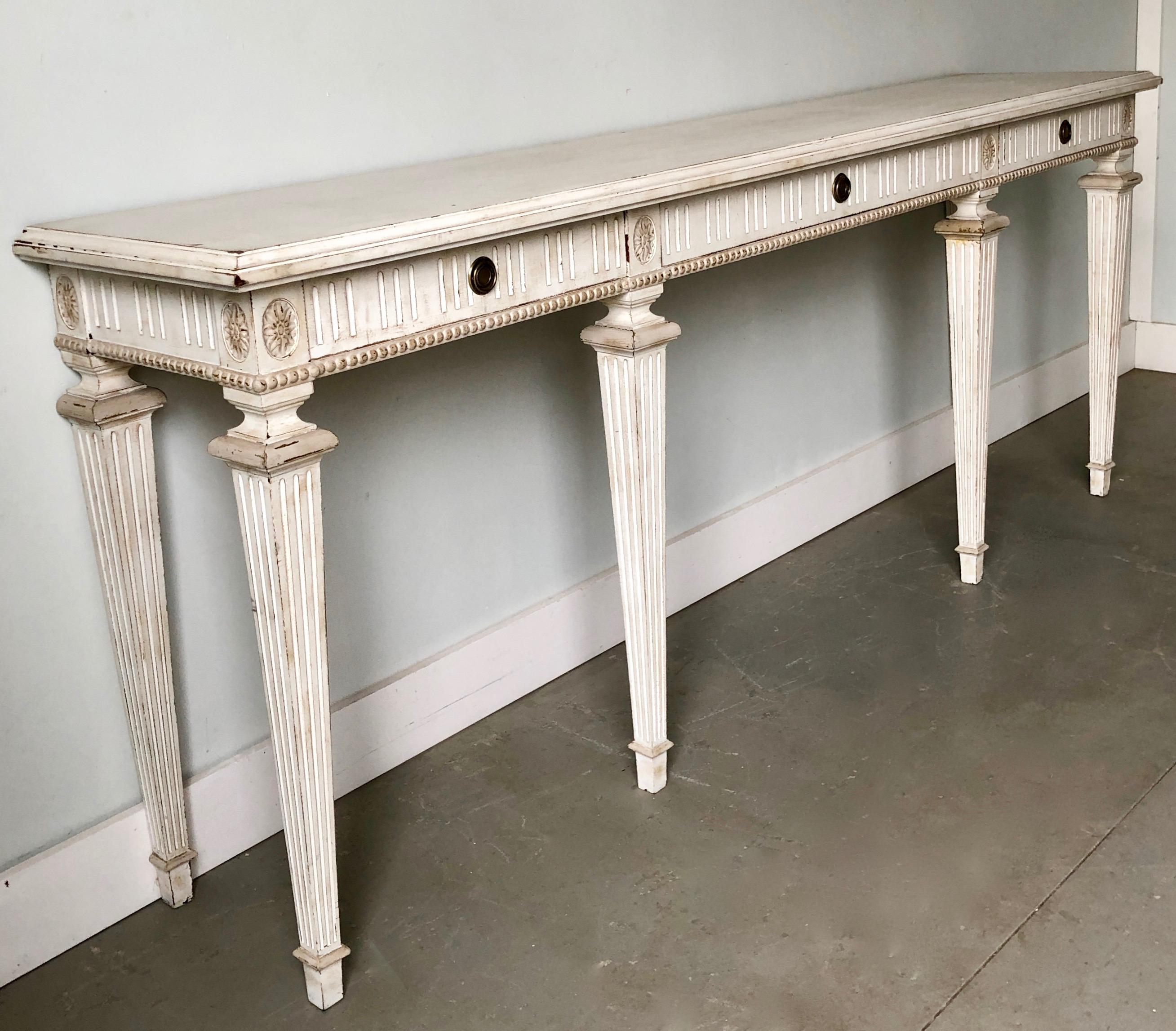 Vintage French Louis XVI style long painted console with freze decorated in Classic fluted motifs and floral medallions.
France, circa 1930-1940.