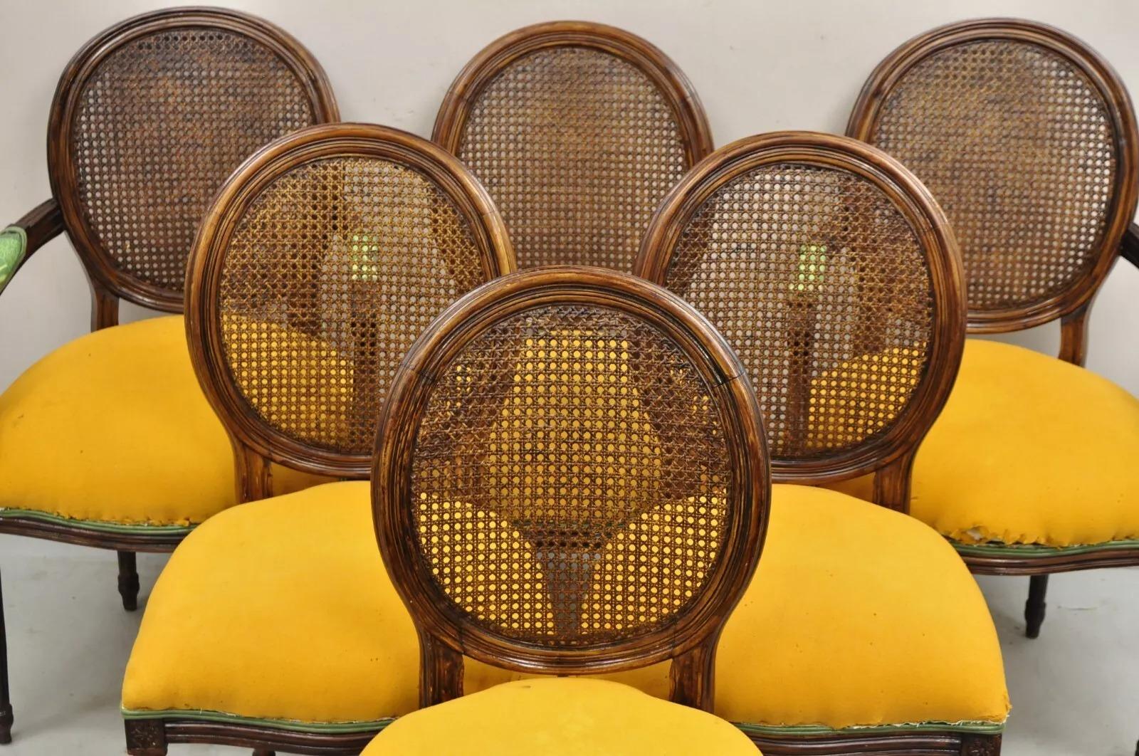 Vintage French Louis XVI Style Oval Cane Back Walnut Dining Chairs - Set of 6. Listing includes 2 armchairs and 4 side chairs. Circa Late 20th Century. Measurements: (2) Armchairs: 38.5