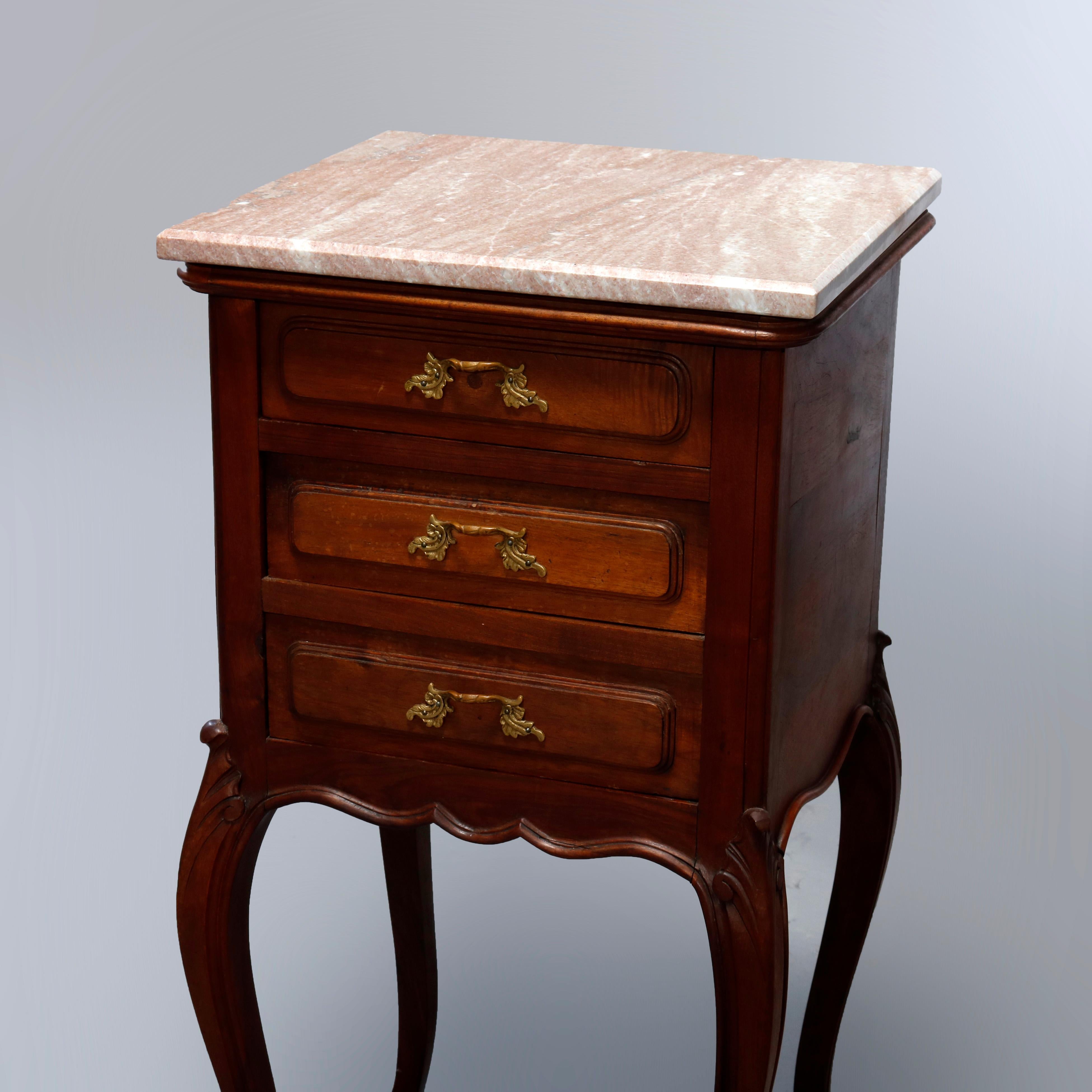 A vintage French Louis XVI style side stand offers marble top over triple drawer walnut case, raised on cabriole legs, cast foliate pulls throughout, 20th century.

Measures: 33.25