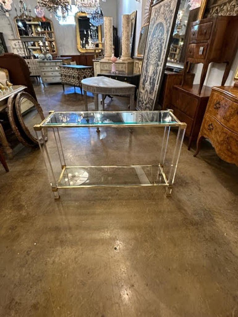 Sleek vintage French lucite and brass console with a glass top and bottom shelf. Creates a stylish look that works in a traditional or modern home. Stunning!!