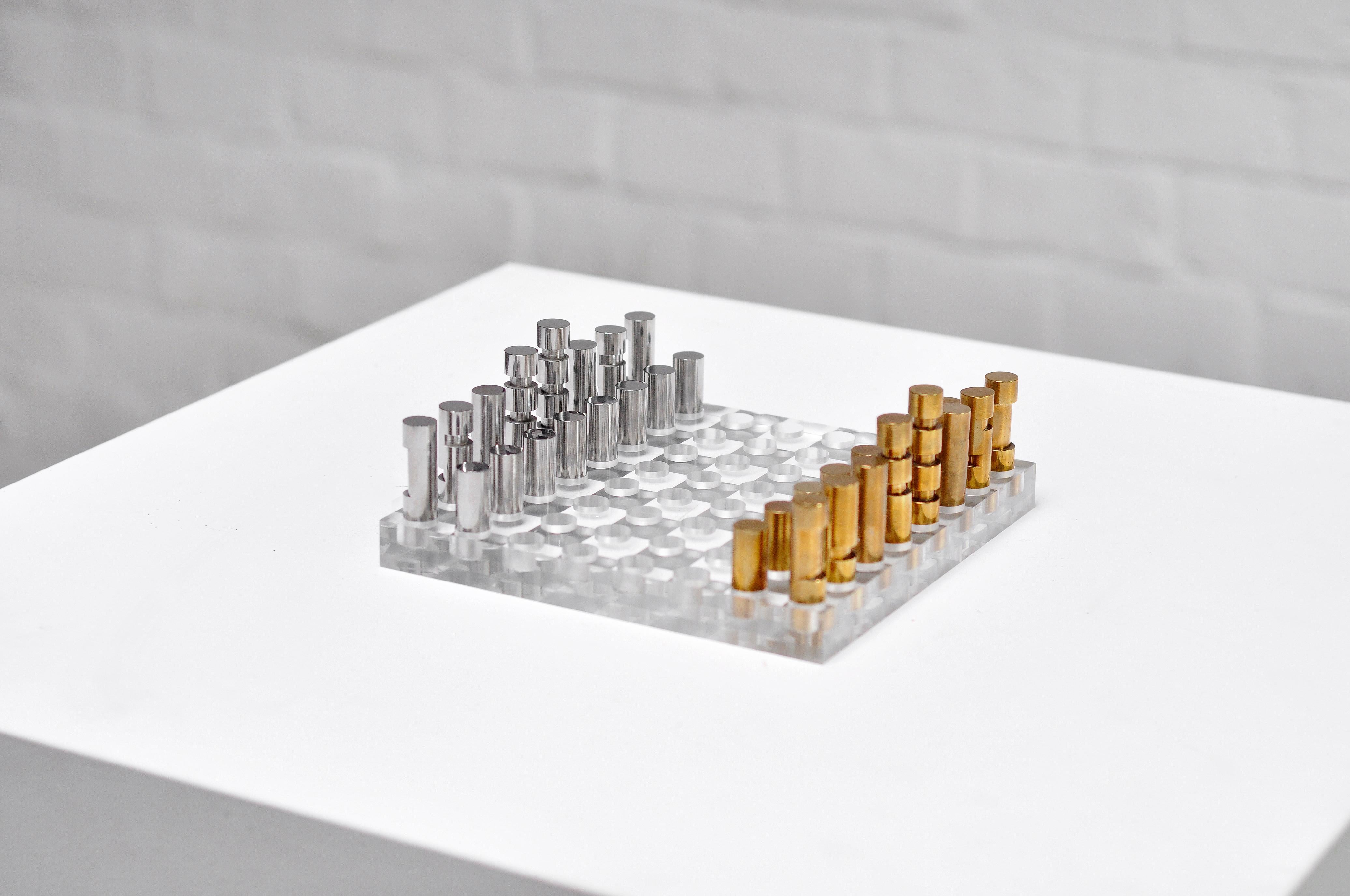 Ein besonderes minimalistisches französisches Schachspiel aus den 1970er Jahren. Es zeichnet sich durch ein modernistisches Design mit einem perforierten Sockel aus dickem Plexiglas aus, der von skulpturalen Metall- und Bronzefiguren gekrönt wird.